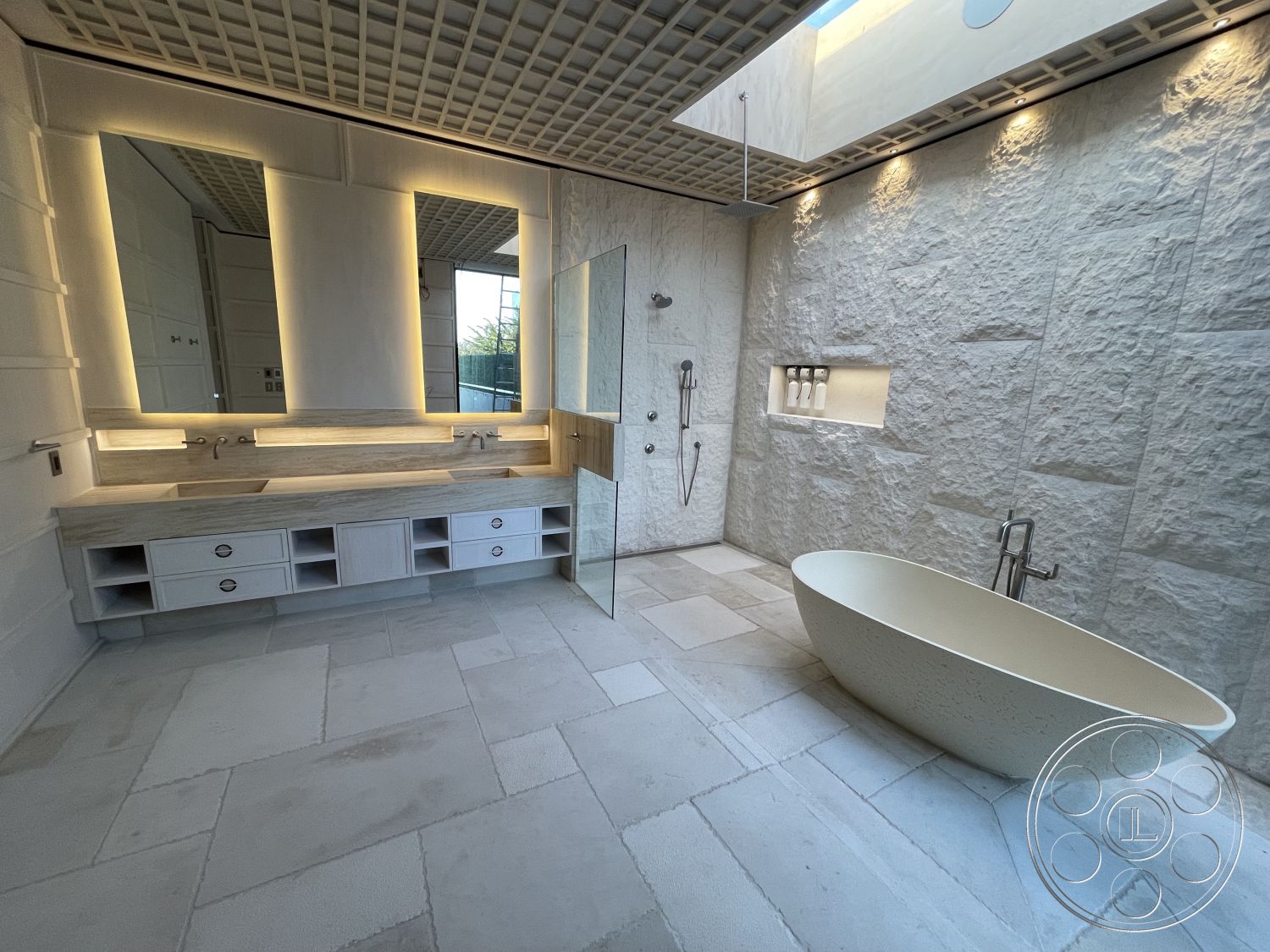 Modern 509 - high ceilings, neutral color palette, open layout, glass shower enclosure, built-in shelving, polished stone flooring, stone feature wall, recessed ceiling lighting, modern minimalist design, freestanding oval bathtub, interior bathroom, textured stone wall treatment, backlit vanity mirrors, double vanity with gray marble countertop, sleek faucet fixtures