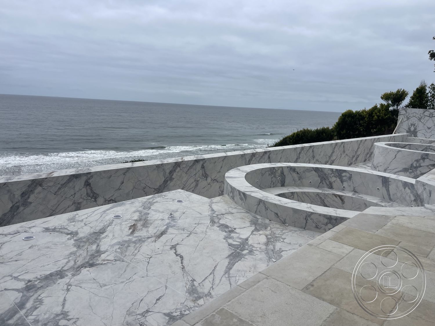 Modern 509 - modern minimalist architecture, exterior marble terrace flooring, white marble hot tub surround, curved marble pool deck, coastal oceanfront view, smooth polished marble surface, outdoor living space with ocean vista, textured stone wall accents, integrated lighting fixtures in flooring, luxurious marble outdoor spaces