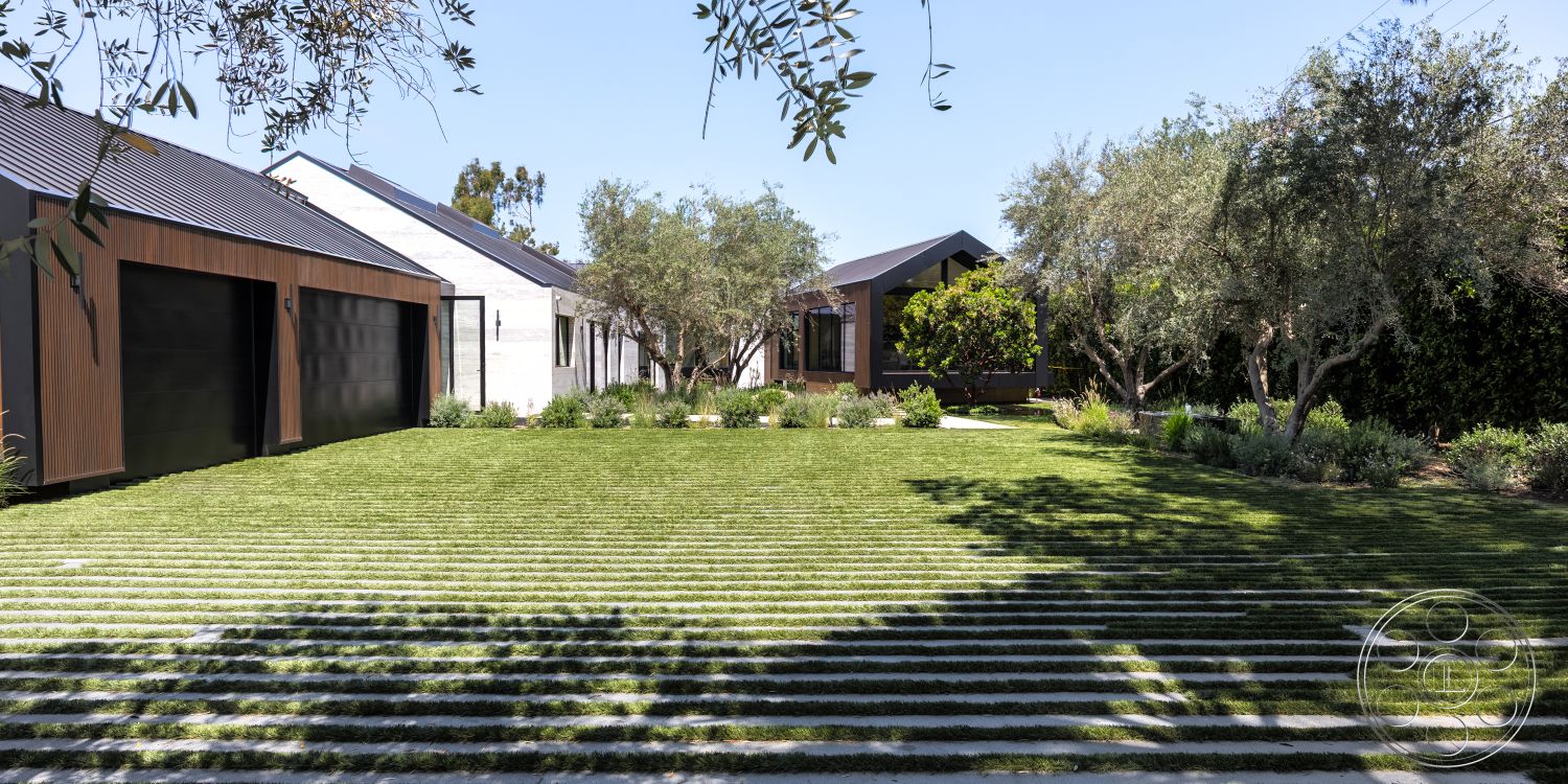 Modern 510 - exterior, open space layout, natural stone path, urban residential setting, hillside location, sustainable landscaping, simple geometric shapes, horizontal wood siding, contemporary home design, minimalist architectural style, minimalist outdoor furniture, outdoor shaded area, striped grass lawn, galvanized steel garage doors, landscaped garden with shrubs, modern flat roof, concrete driveway with grass strips, courtyard with trees, mixed materials facade, inviting garden space