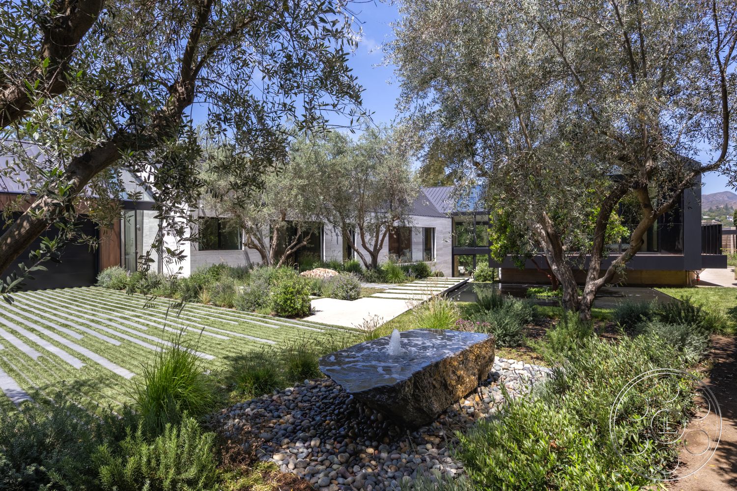 Modern 510 - exterior, modern architecture, flat roof, minimalist design, large glass windows, concrete pathway, olive trees, sunny outdoor space, raised garden beds, zen garden vibe, bamboo landscaping, natural stone boulders, natural stone water feature, gravel garden bed, panoramic mountain views, soft green landscaping, wood accent siding, geometric garden layout, contemporary backyard, open air patio