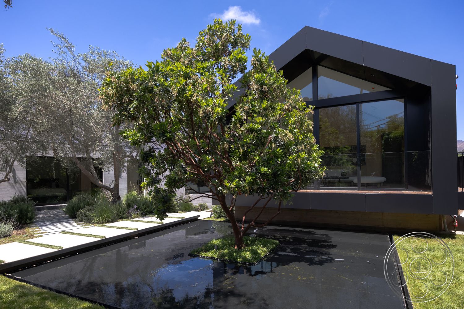 Modern 510 - large floor-to-ceiling windows, urban residential setting, sustainable landscaping, geometric garden design, concrete patio flooring, natural grass lawn, minimalist architectural style, landscaped garden with native plants, black metal exterior cladding, modern angular roof shapes, rectangular stepping stone pathway, glossy black water feature, exposed wood deck, open-plan living space views, translucent glass railings, exterior lighting details