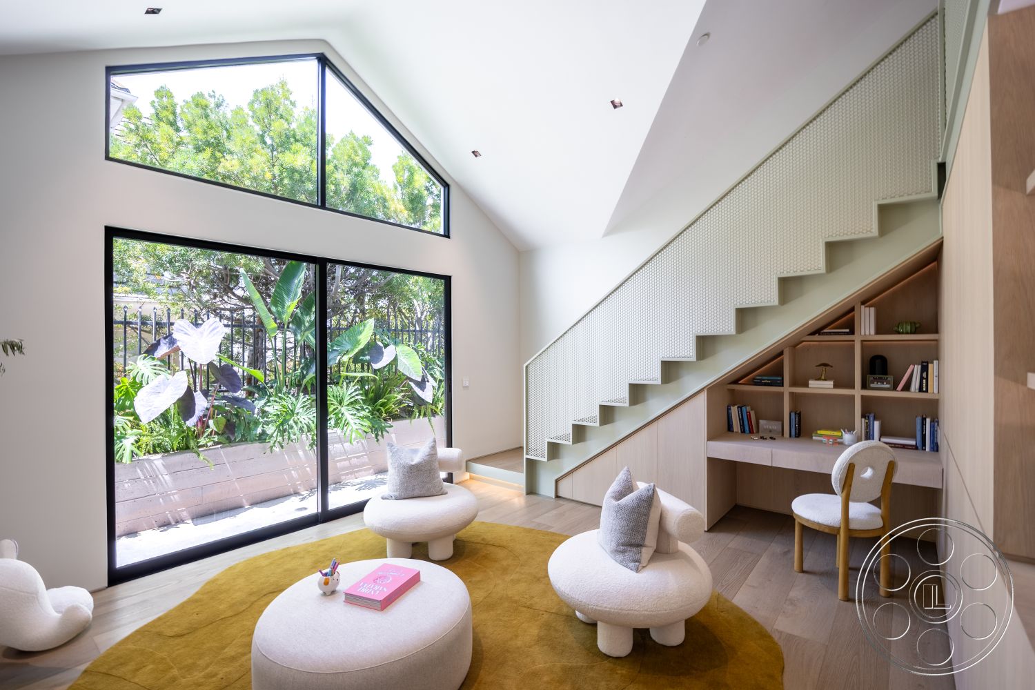 Modern 510 - interior cozy reading nook, interior hardwood flooring, interior minimalist design elements, interior open-concept living area, interior smooth plaster walls, interior light wood cabinetry, exterior large floor-to-ceiling windows, interior triangular vaulted ceiling, interior modern floating stairs, interior custom built-in shelves, interior circular area rug, exterior lush tropical landscaping, interior soft pastel color palette, interior geometric furniture shapes, exterior private courtyard view, interior playful accent pieces, children's play area