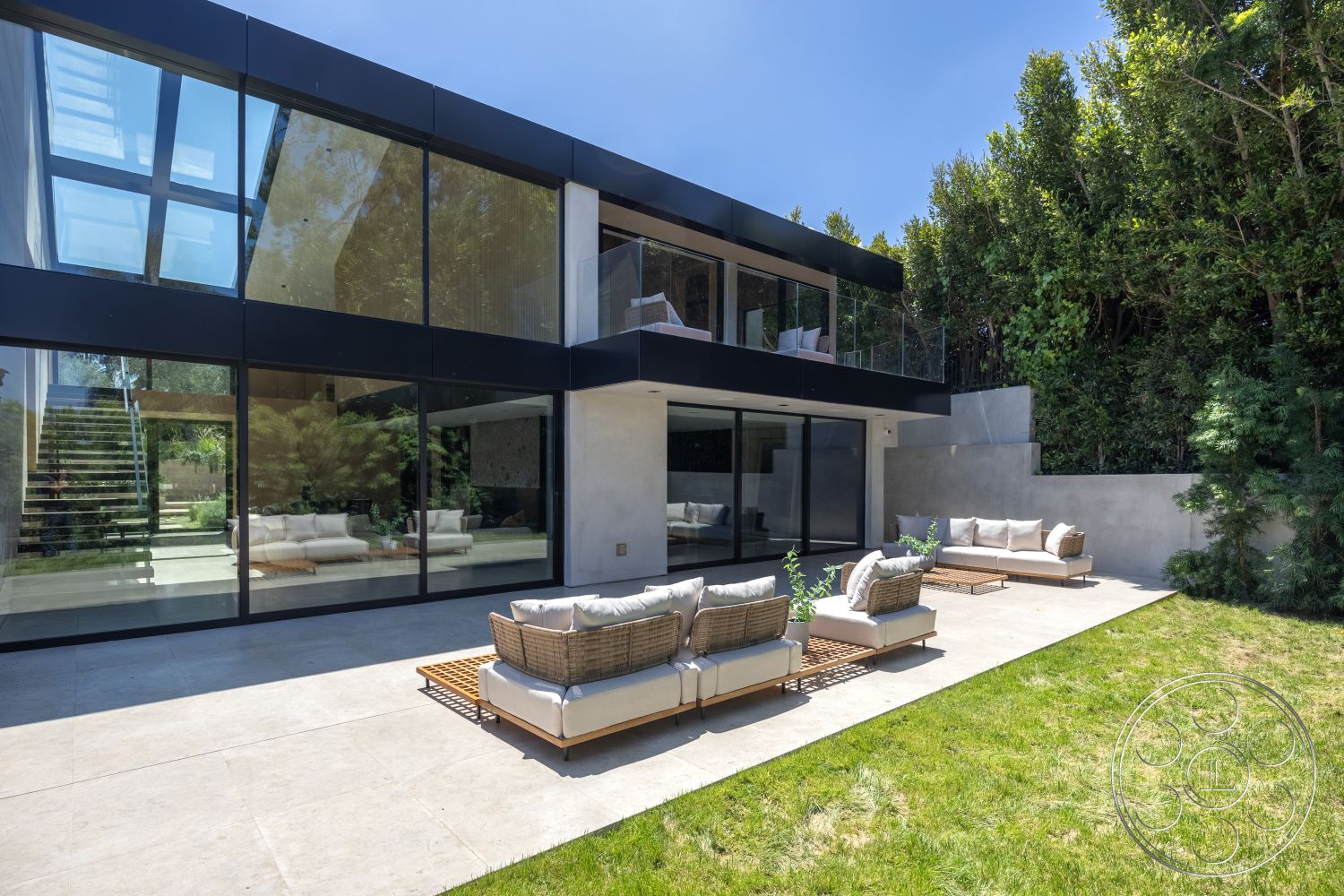 Modern 510 - natural light, contemporary home, sliding glass doors, floor-to-ceiling windows, modern outdoor seating, modern architectural style, greenery backdrop, concrete patio flooring, flat roof design, open-air patio, multilevel, urban backyard setting, minimalist landscape, textured concrete wall, clear sky view, steel stair railings, sun-drenched exterior, exterior glass walls, wood deck lounge chairs, luxury outdoor area, rectangular patio