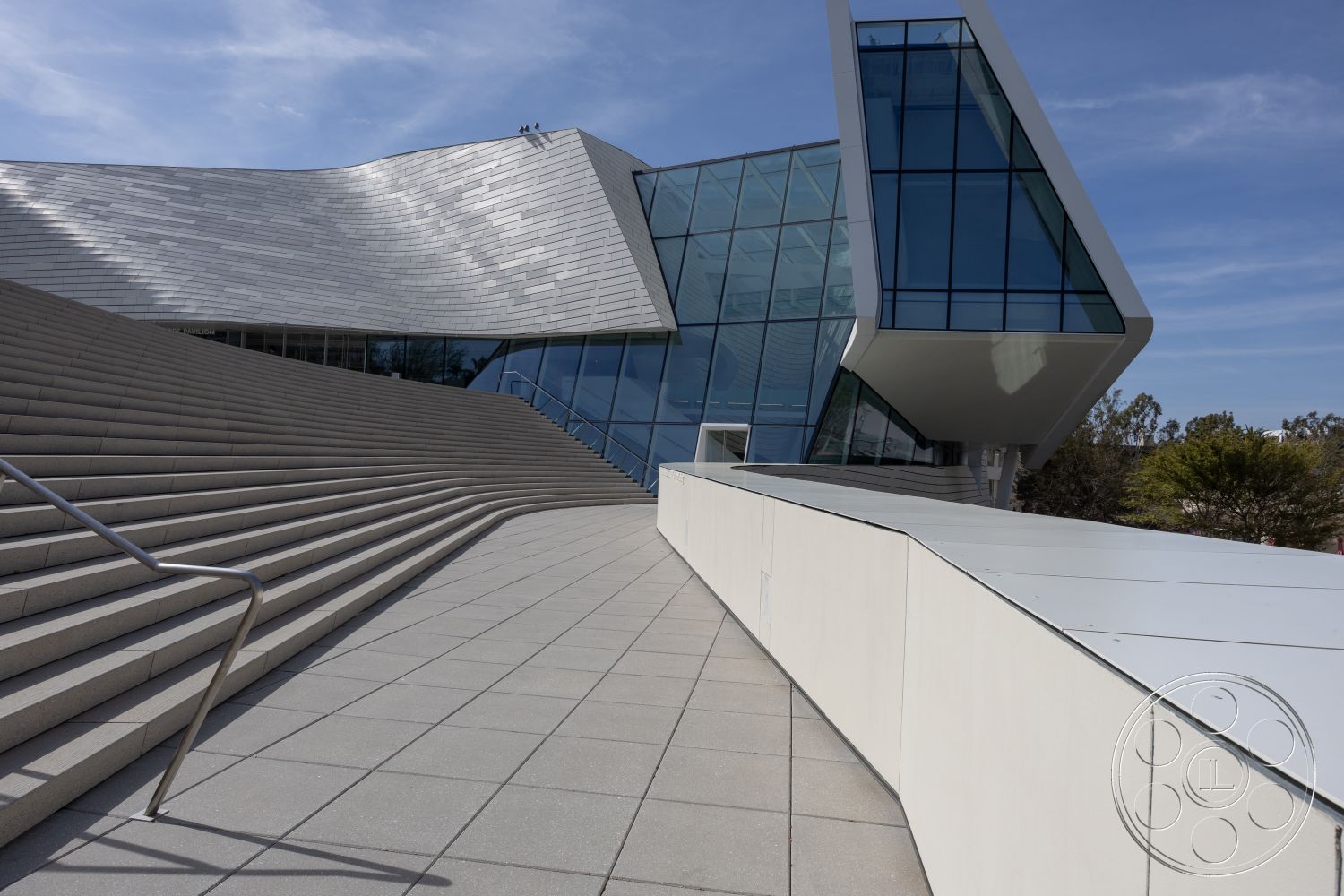 Museum 4 - exterior, glass facade, open outdoor space, urban architecture, modern minimalist style, angular architectural forms, aluminum cladding exterior, multifaceted roof design, concrete steps with uniform risers, expansive glass windows, textured concrete patio flooring, stepped terrace layout, surrounding landscaped greenery, integrated stair railings, horizontal alignments in façade, dynamic rooflines, sculptural building design