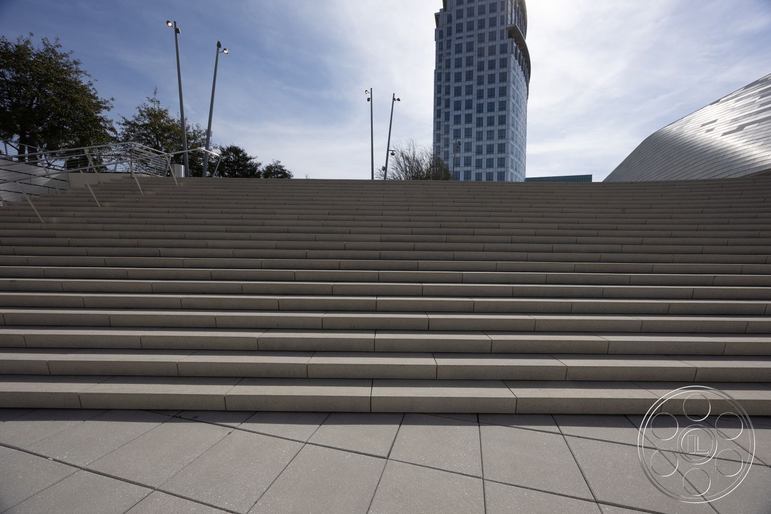 Museum 4 - landscaped surroundings, urban setting, concrete steps, textured concrete surface, smooth concrete finish, modern architectural design, stainless steel handrails, exterior steps, LED light fixtures, rectangular staircase, city skyline back view, public plaza access