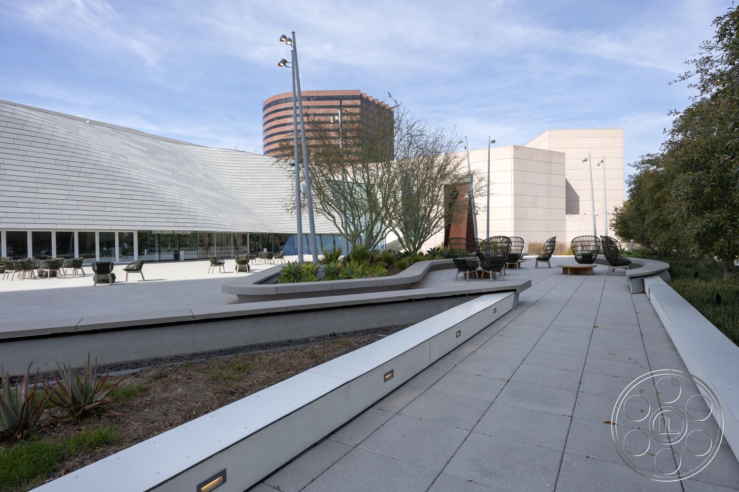 Museum 4 - textured stone wall, outdoor seating area, metal railings, community gathering space, planted garden beds, contemporary urban setting, landscaped garden area, natural light integration, interior open floor plan, flat roof structure, modern architectural design, exterior concrete paver walkway, glass window facade, angular building forms, luxury public space, public exhibition space, soft landscaping elements, urban plaza environment, sculptural bench seating, lightweight modern furniture