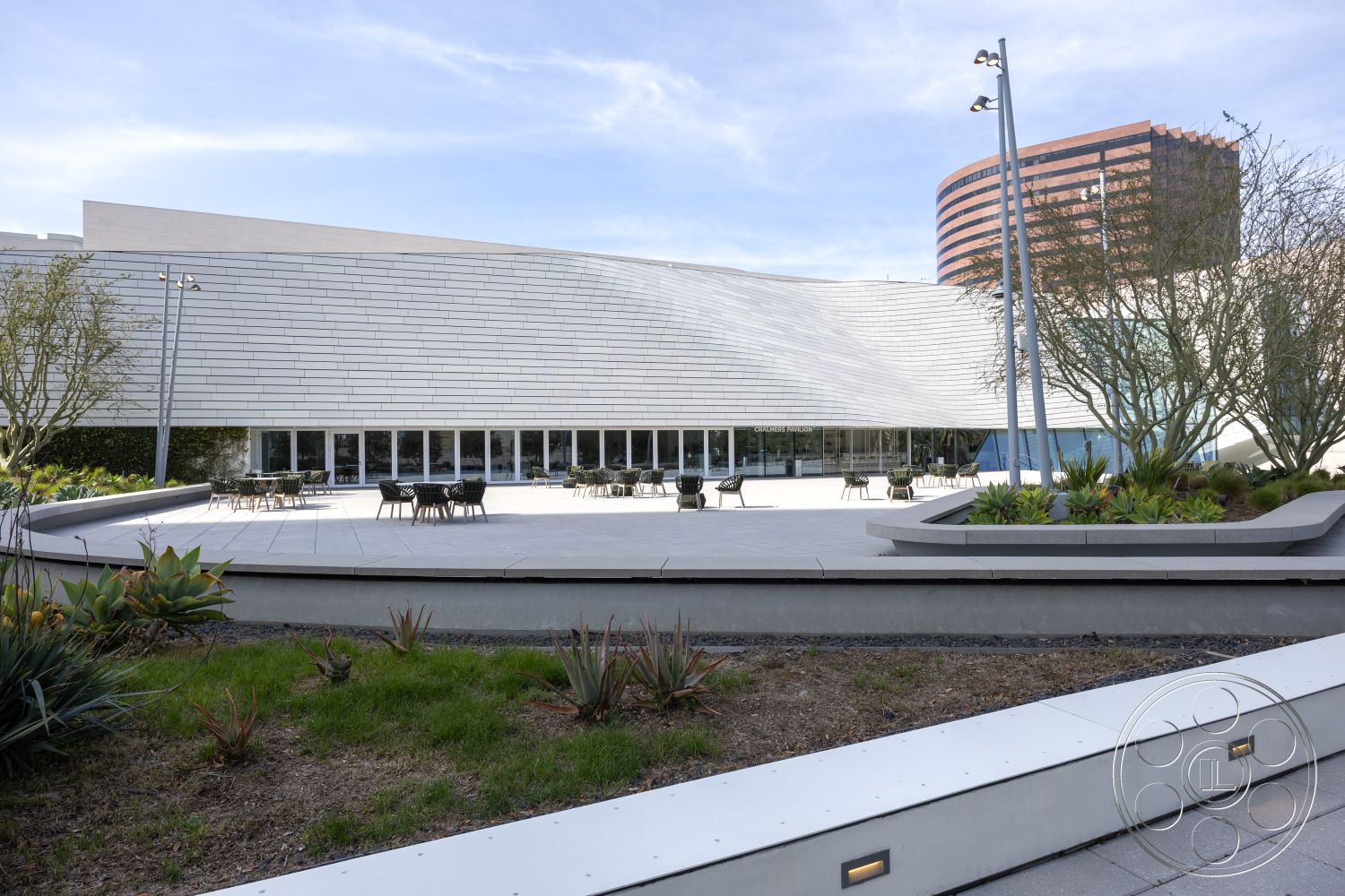 Museum 4 - exterior concrete patio floor, exterior landscaped garden beds, exterior sleek angled roof design, exterior glass windows with steel frames, exterior circular seating area, exterior built-in seating, exterior modern architectural lines, exterior aluminum light fixtures, exterior smooth stucco wall finish, exterior landscaped greenery, exterior urban office building, exterior contemporary minimalism, exterior outdoor dining space, exterior curved hardscape design