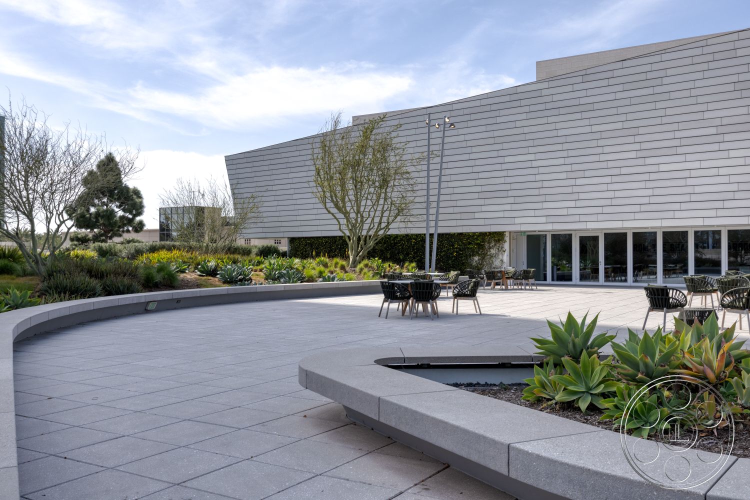 Museum 4 - smooth concrete surface, open-air environment, landscaped garden area, minimalist architectural style, contemporary outdoor dining area, textured stone planters, natural light filled space, exterior concrete patio flooring, low-maintenance succulent garden, curved concrete bench seating, modern glass facade, metal outdoor light fixtures, geometric outdoor design, horizontal wood slats accent wall, urban outdoor gathering space, paved walkway around greenery