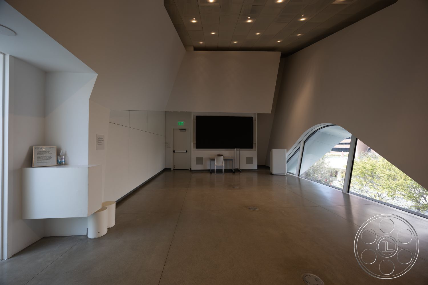 Museum 4 - contemporary design, open layout, modern lighting fixtures, minimalist furniture, floor-to-ceiling windows, white painted walls, natural light focus, interior concrete flooring, exposed angular wall design, curvilinear architectural features, geometric ceiling shapes, built-in wall niches