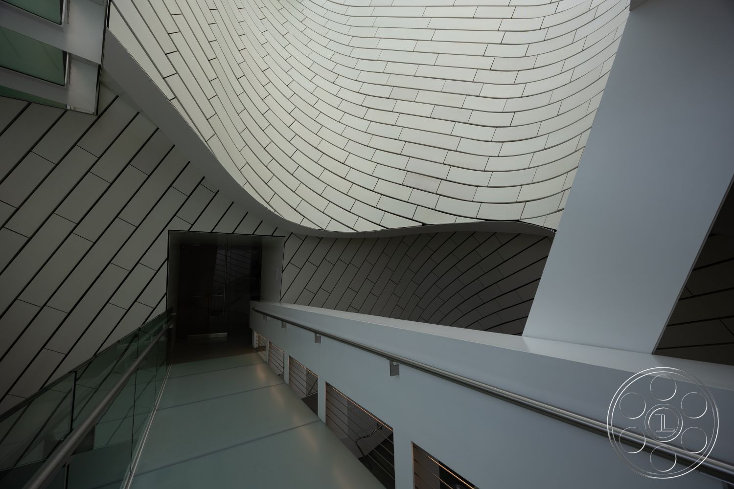 Museum 4 - interior textured wall panels, interior open floor plan, interior glass railing, interior geometric shapes, interior ambient lighting design, interior curved wall tiles, interior smooth glass floors, interior asymmetrical architectural forms, interior contemporary minimalist design, interior high ceiling, interior linear lighting fixtures, interior natural light access, interior sleek modern aesthetics, interior fluid architectural lines, interior stone-like floor treatment