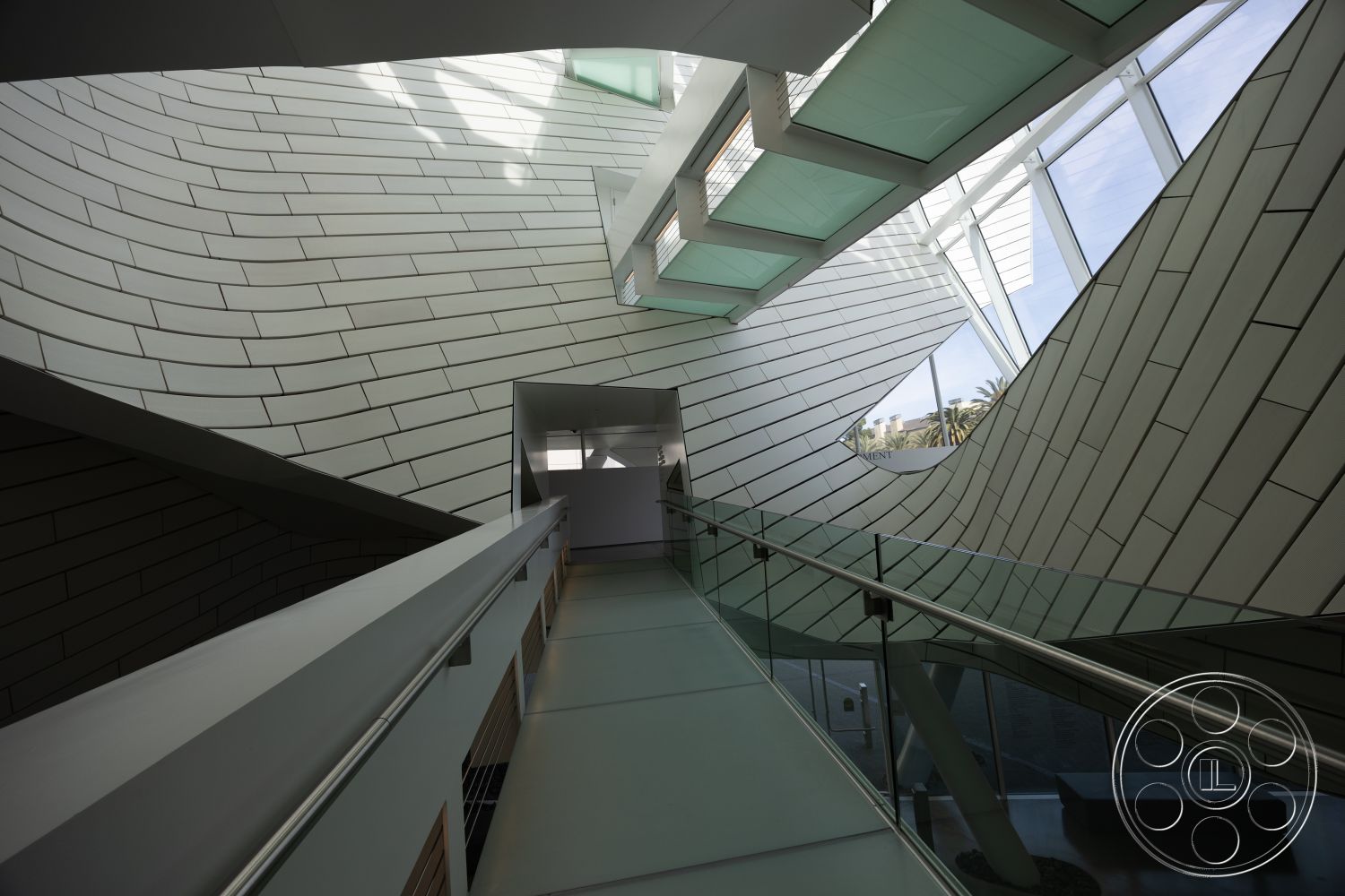 Museum 4 - open space layout, smooth concrete flooring, textured wall surfaces, warm wood accents, organic design elements, modern minimalist style, contemporary architectural details, natural light infusion, interior glazed tile walls, curved glass skylights, steel railing with glass panels, dynamic architectural shapes, biophilic design features, angled wall surfaces, unique geometric forms, high-tech materials, avant-garde design, high ceiling with sloped angles, light-reflecting surfaces, sustainable building practices