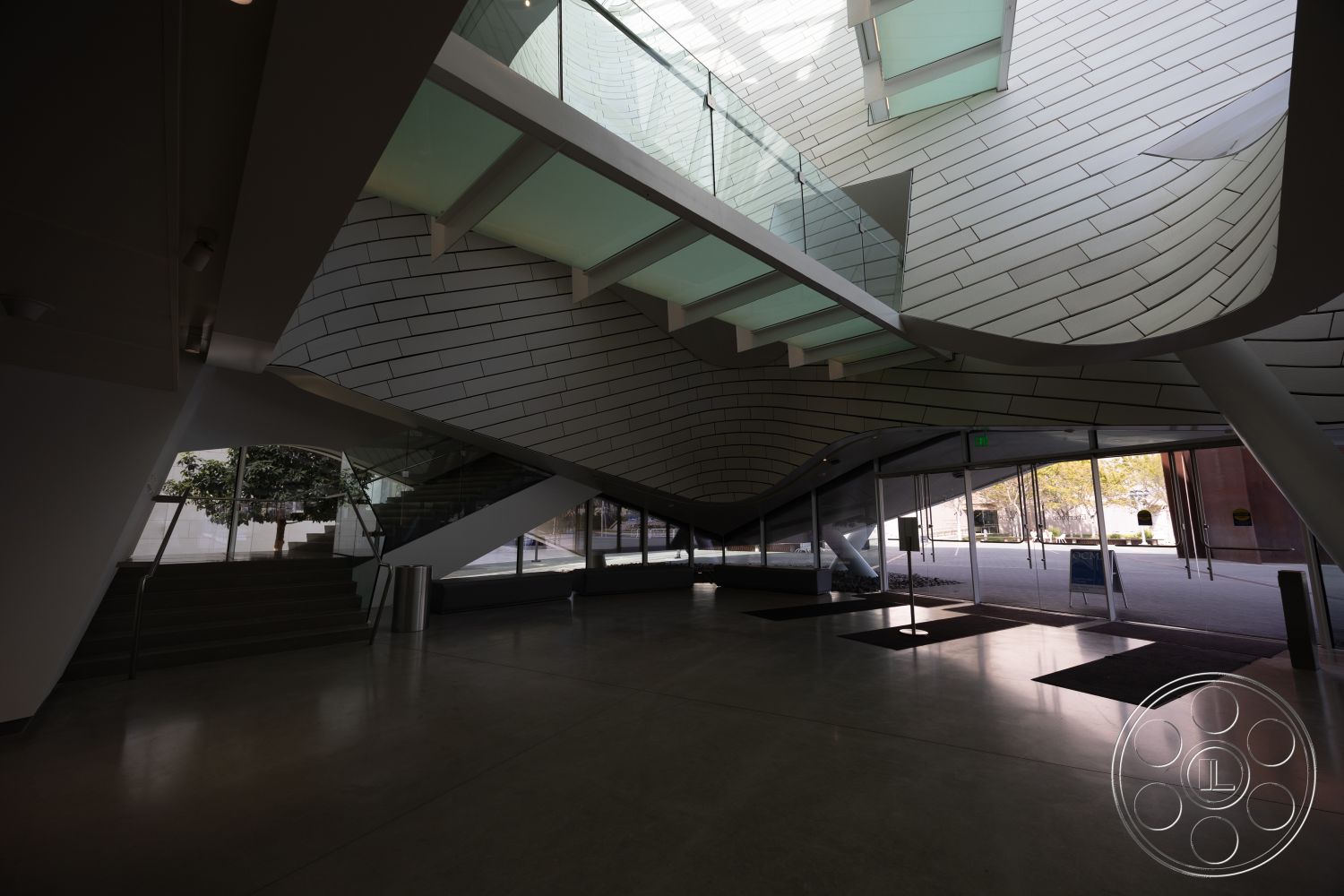 Museum 4 - sliding glass doors, reflective surfaces, vaulted ceiling, integrated greenery, sustainable design features, modern minimalist aesthetic, open floor plan interior, textured plaster walls interior, natural light-filled atrium, glass curtain wall exterior, steel stair railings interior, urban art installation, exposed concrete floors interior, curved concrete ceiling, floating glass staircase, angular roofline exterior, polycarbonate skylight, articulated spatial forms, triangular architectural features, non-linear structural elements