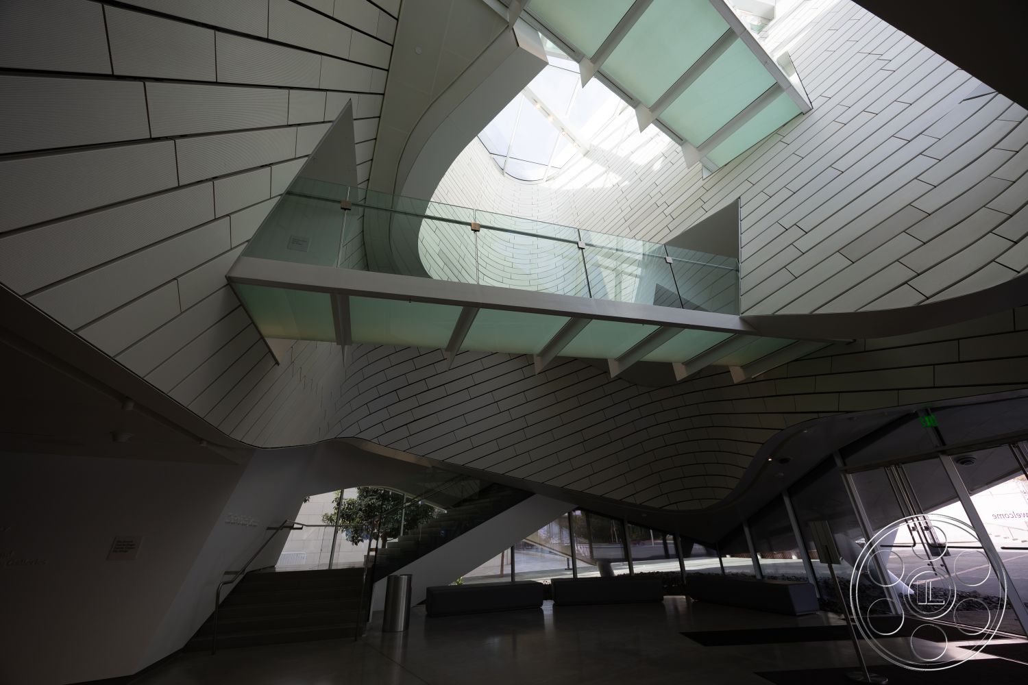 Museum 4 - interior vaulted ceiling, exterior modern architectural style, interior polished concrete flooring, interior glass partition walls, interior linear lighting fixtures, interior ceramic wall tiles, interior glass staircase, exterior curved façade, interior metal handrails, exterior textured building cladding, interior open atrium space, exterior geometric roof design, interior plant wall feature, interior multifunctional common area, exterior landscaped entryway, interior ambient natural lighting