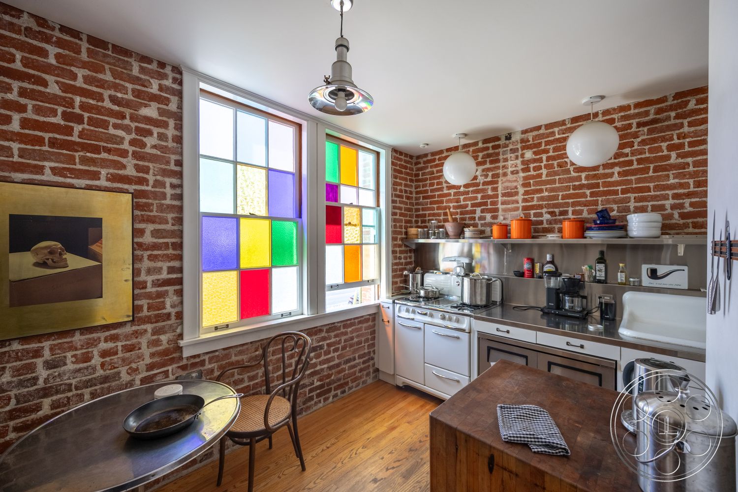 Studio 100 - kitchen, exposed brick accent wall interior, stainless steel kitchen countertops interior, hardwood kitchen floors interior, round dining table interior, pendant light fixtures interior, colorful stained glass windows interior, modern kitchen appliances interior, open shelving kitchen storage interior, metallic kitchen accents interior, contemporary kitchen design interior