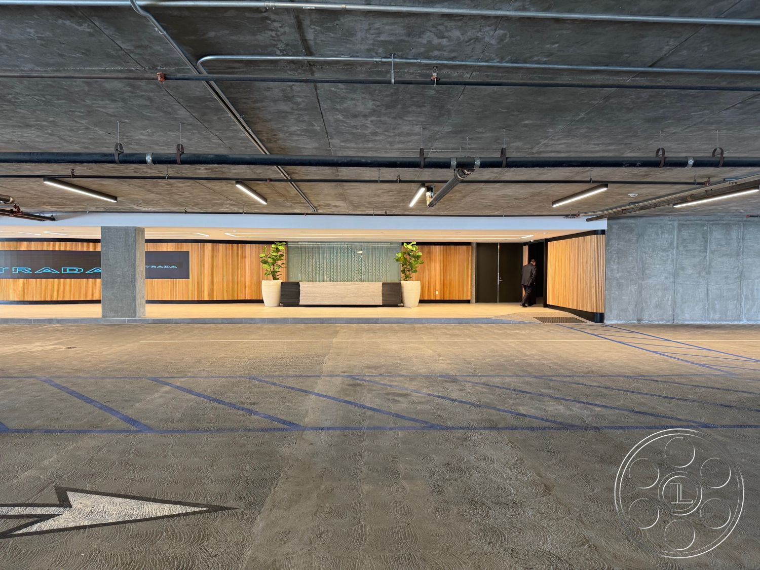 Office 121 - minimalist design elements, polished concrete floors, industrial lighting fixtures, exposed concrete ceiling, floor-to-ceiling glass walls, contemporary reception area, urban interior space, wood panel wall accents, modern parking structure, landscape planter with greenery