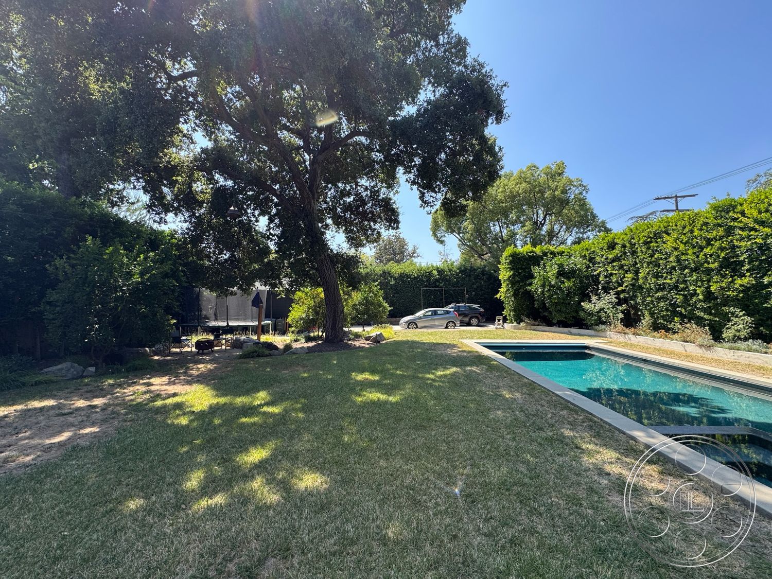 Craftsman 20 - exterior, surrounding greenery, grass lawn, outdoor furniture, city skyline view, natural stone pathway, tall hedges, rectangular pool, tree shade, urban backyard, modern residential architecture, landscaped garden setting, concrete pool border, hardwood outdoor patio