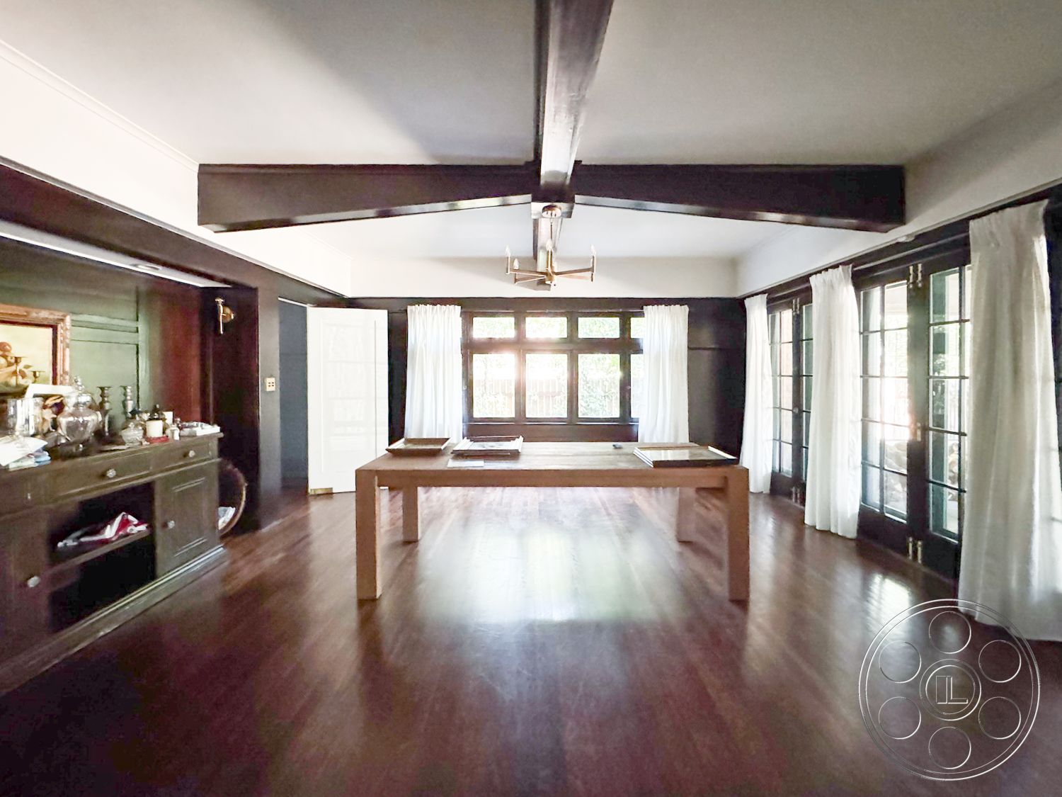 Craftsman 20 - hardwood flooring, floor-to-ceiling windows, dark wood paneling, rectangular dining table, private garden view, exposed wood ceiling beams, interior dining area, Craftsman architectural style, traditional chandelier lighting, Crown molding details, plantation-style window treatments
