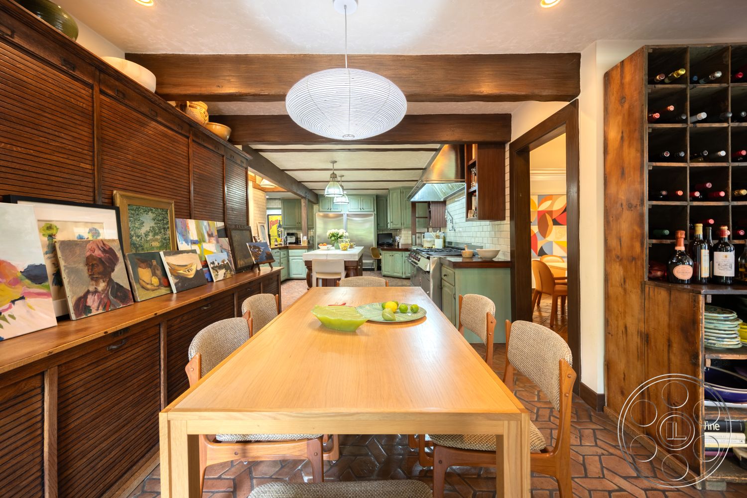 Mansion 2 - neutral painted walls interior, exposed wood ceiling beams interior, indoor plant decor interior, glass pendant lighting interior, square dining table interior, brick kitchen flooring interior, custom built-in wooden cabinets interior, subway tile backsplash kitchen interior, wooden dining chairs with fabric upholstery interior, wood slab dining table interior, art display wall with paintings interior, open-concept living space interior, pastel-colored cabinetry kitchen interior, rustic wooden wine rack interior, textured plaster wall treatment interior, vaulted ceiling kitchen interior, historic home interior, cozy dining area interior