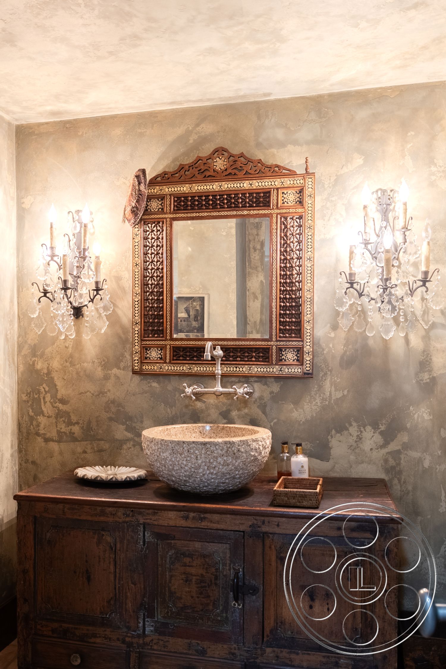 Mansion 2 - wooden countertop, soft lighting ambiance, textured plaster bathroom walls, vintage wooden bathroom cabinet, stone vessel sink, ornate wooden mirror frame, crystal wall sconces, elegant bathroom decor, rustic bathroom styling