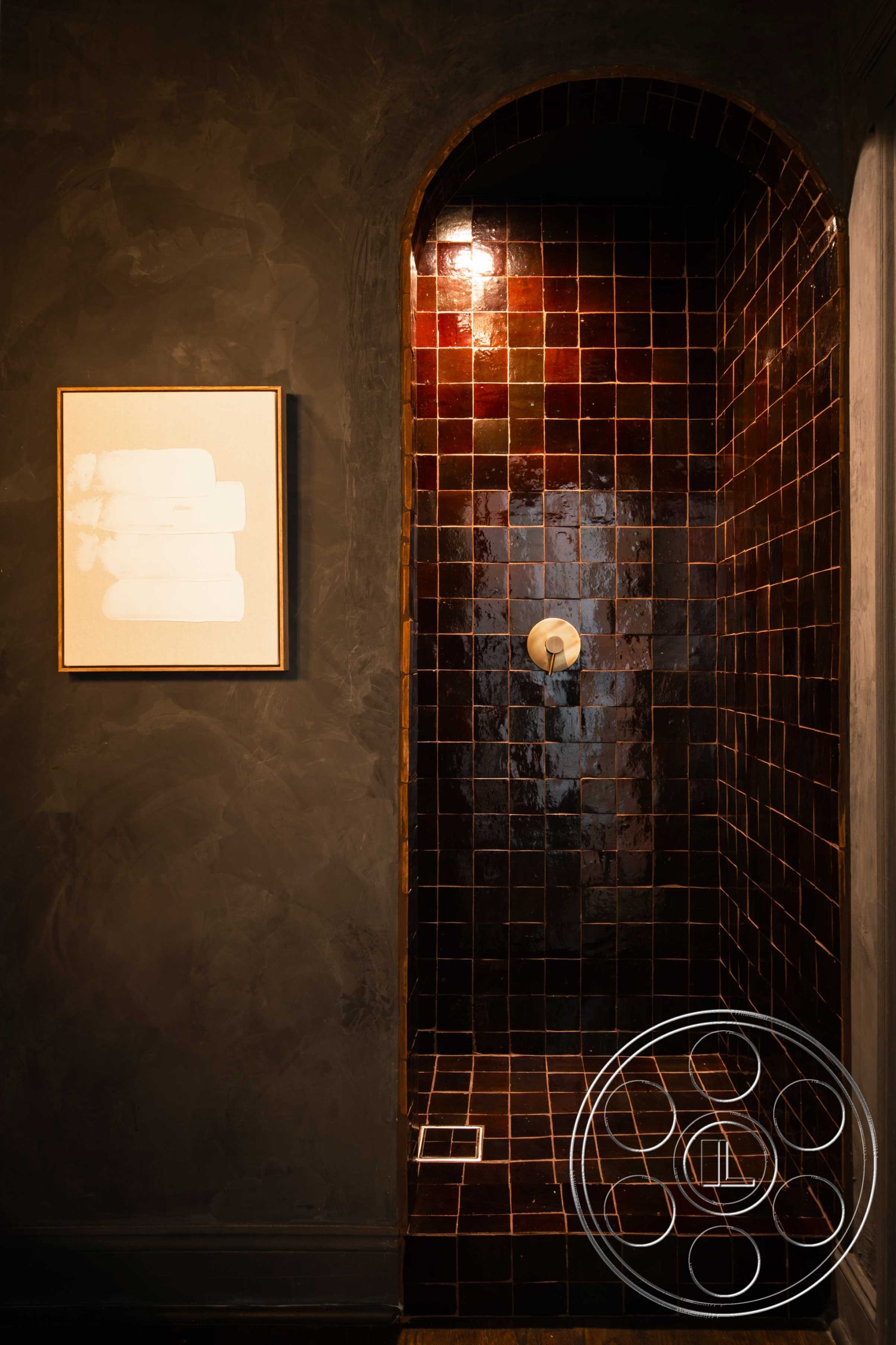 Spanish 166 - textured plaster wall finish, framed artwork on wall, interior shower with arched entryway, glazed ceramic tile shower walls, dark brown subway tile shower design, modern minimalist bathroom interior, brass shower fixture, custom shower drain, luxury spa-like shower space