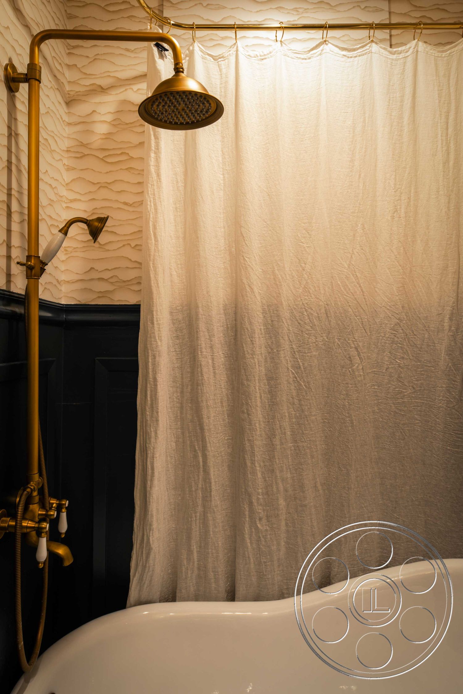 Spanish 166 - white freestanding bathtub, textured wall treatment, interior bath space, gold shower fixtures, wave-patterned wall paneling, light fabric shower curtain, dark wood wainscoting, traditional shower head, curved bathtub edge