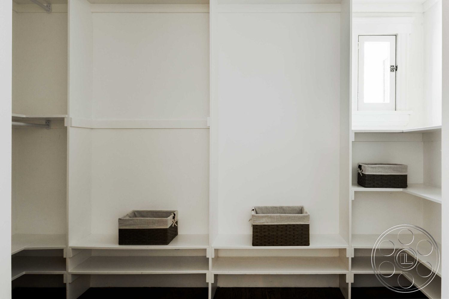 Spanish 166 - minimalist design, woven storage baskets, dark hardwood flooring, natural light from window, white painted walls, open shelving units, interior walk-in closet, custom built-in storage, organized storage space