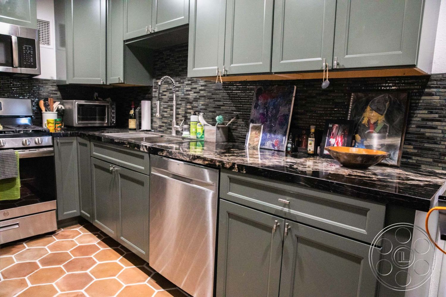 Medit 31 - open floor plan, stainless steel appliances, hexagon tile flooring, artistic wall decor, under-cabinet lighting, modern kitchen design, interior kitchen, granite kitchen countertops, grey shaker cabinets, black mosaic tile backsplash, built-in microwave, contemporary faucet fixture, dishwasher integrated, kitchen utensils storage, stylish fruit bowl centerpiece, ambient kitchen lighting