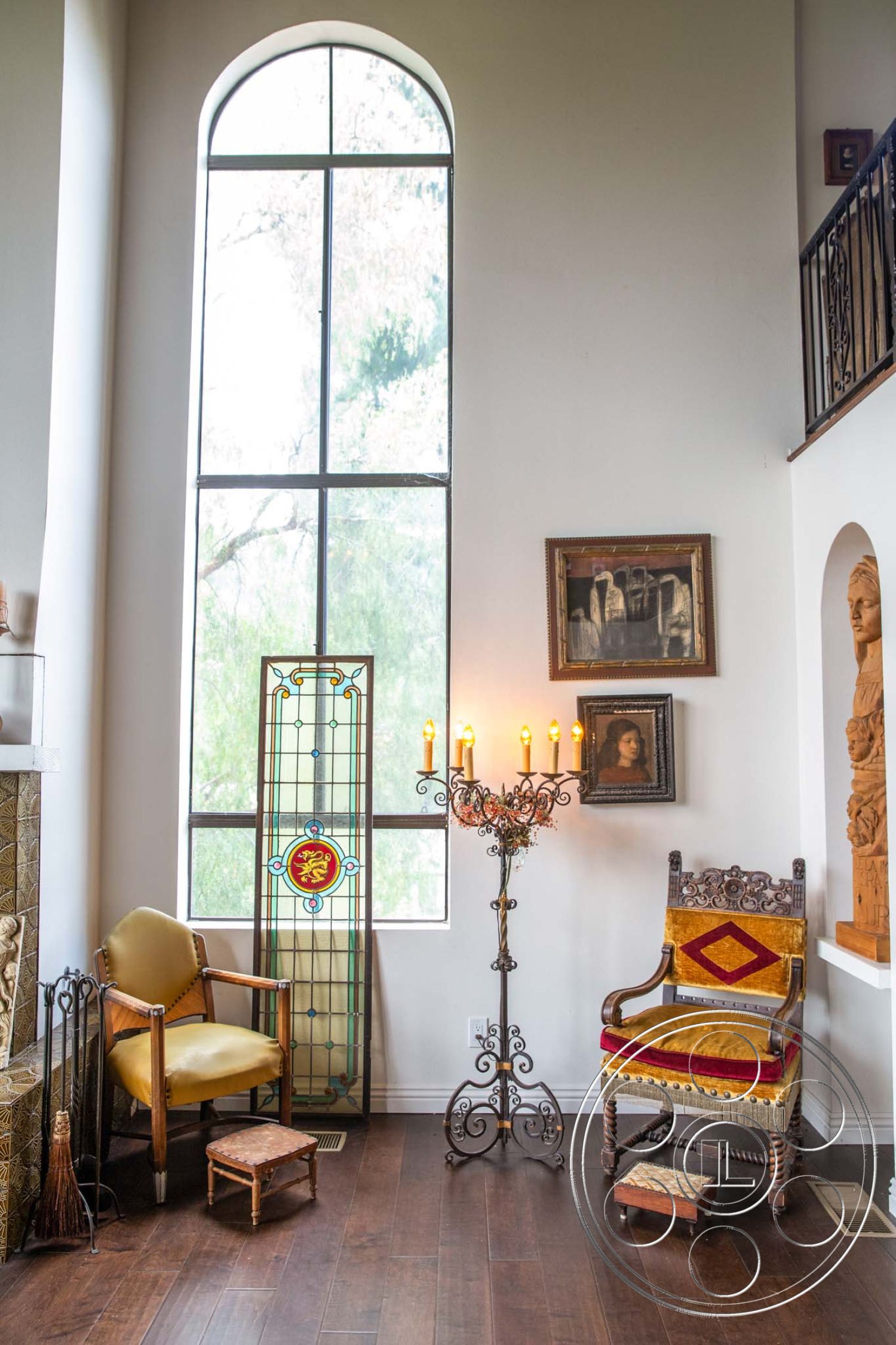 Medit 31 - artistic wall decor, wooden side table, cozy reading nook, hardwood living room floors, textured plaster wall, interior decor, exposed brick fireplace surround, arched floor-to-ceiling windows, stained glass window accent, iron candle holder, vintage wooden chairs, corner wood cabinet, rustic ceiling details