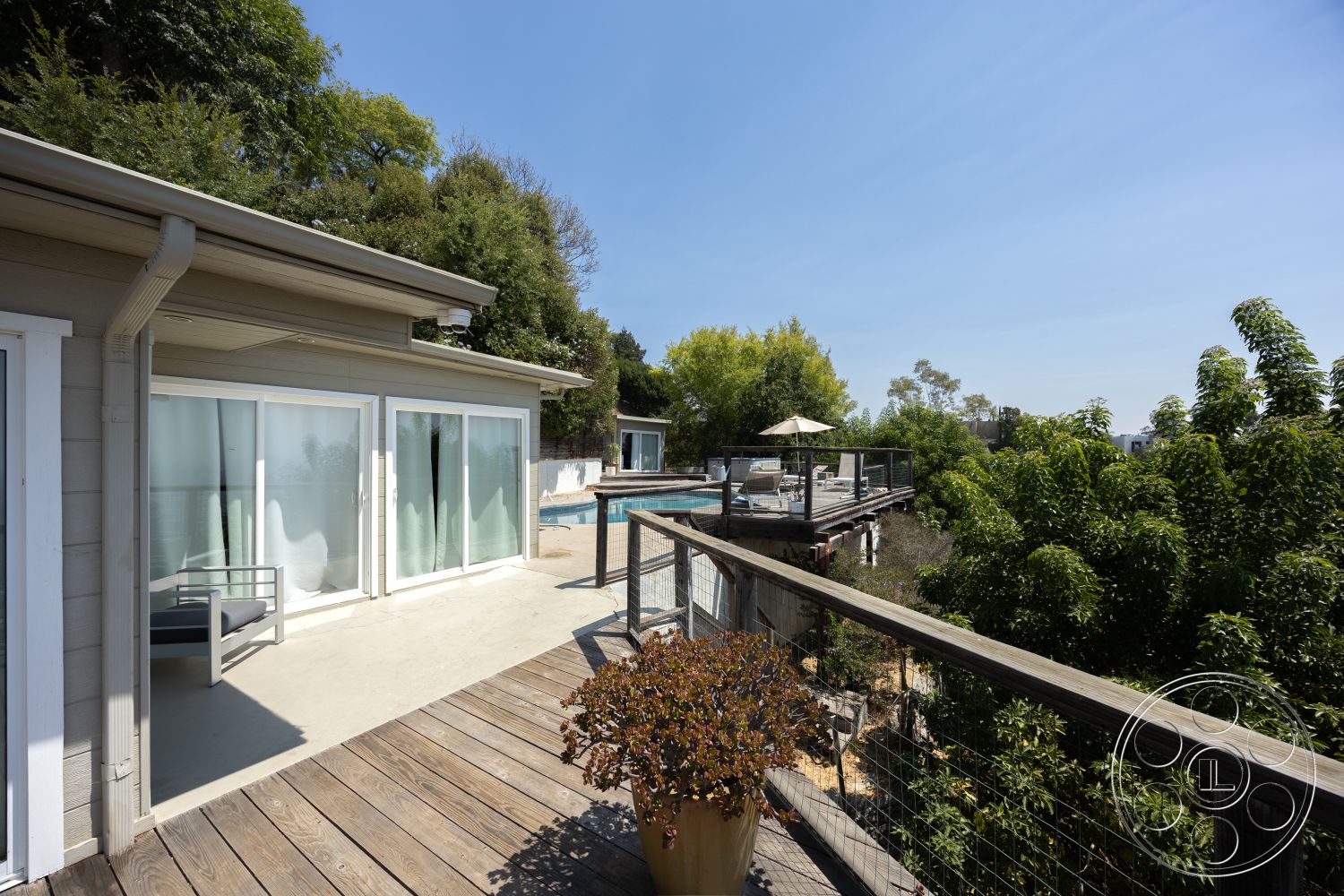 Retro 294 - glass sliding doors, outdoor seating area, modern architectural style, lap pool, flat roof design, landscaped garden area, exterior wooden deck, concrete pool patio, wooden railing with wire mesh, wood-clad house exterior, green foliage surrounding property, sunny urban hillside setting