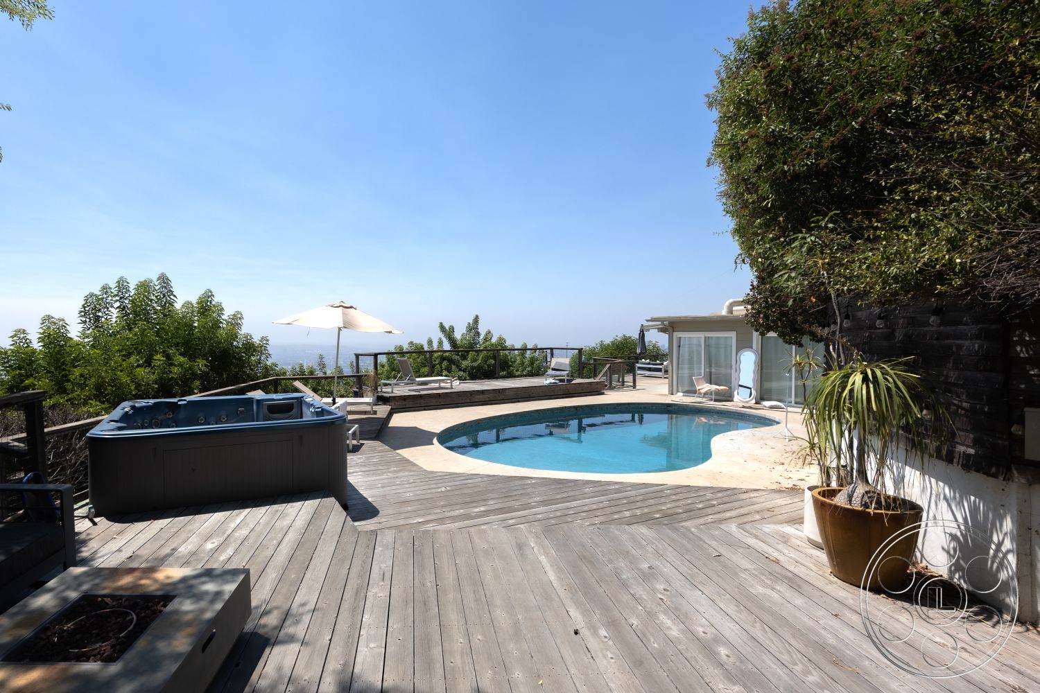 Retro 294 - landscaped garden, glass sliding doors, surrounding greenery, outdoor lounge chairs, patio umbrella, oval swimming pool, concrete pool border, exterior wooden deck flooring, hot tub installation, view of sky and horizon