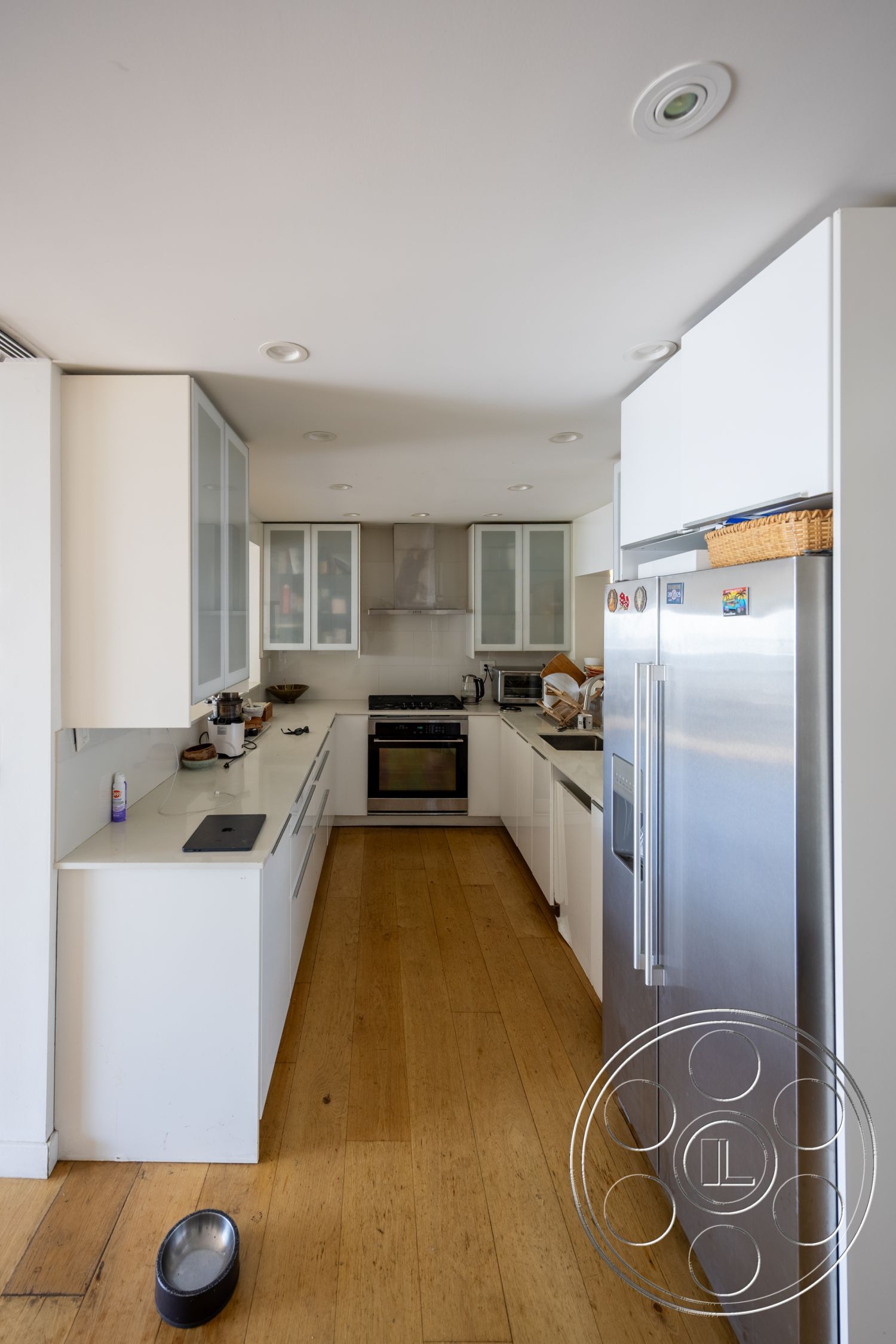 Retro 294 - minimalist decor, neutral color palette, hardwood flooring, recessed lighting, stainless steel appliances, functional workspace, white cabinetry, glass cabinet doors, modern kitchen design, marble kitchen countertops, open kitchen layout, interior kitchen, built-in kitchen storage, sleek backsplash, contemporary kitchen detail