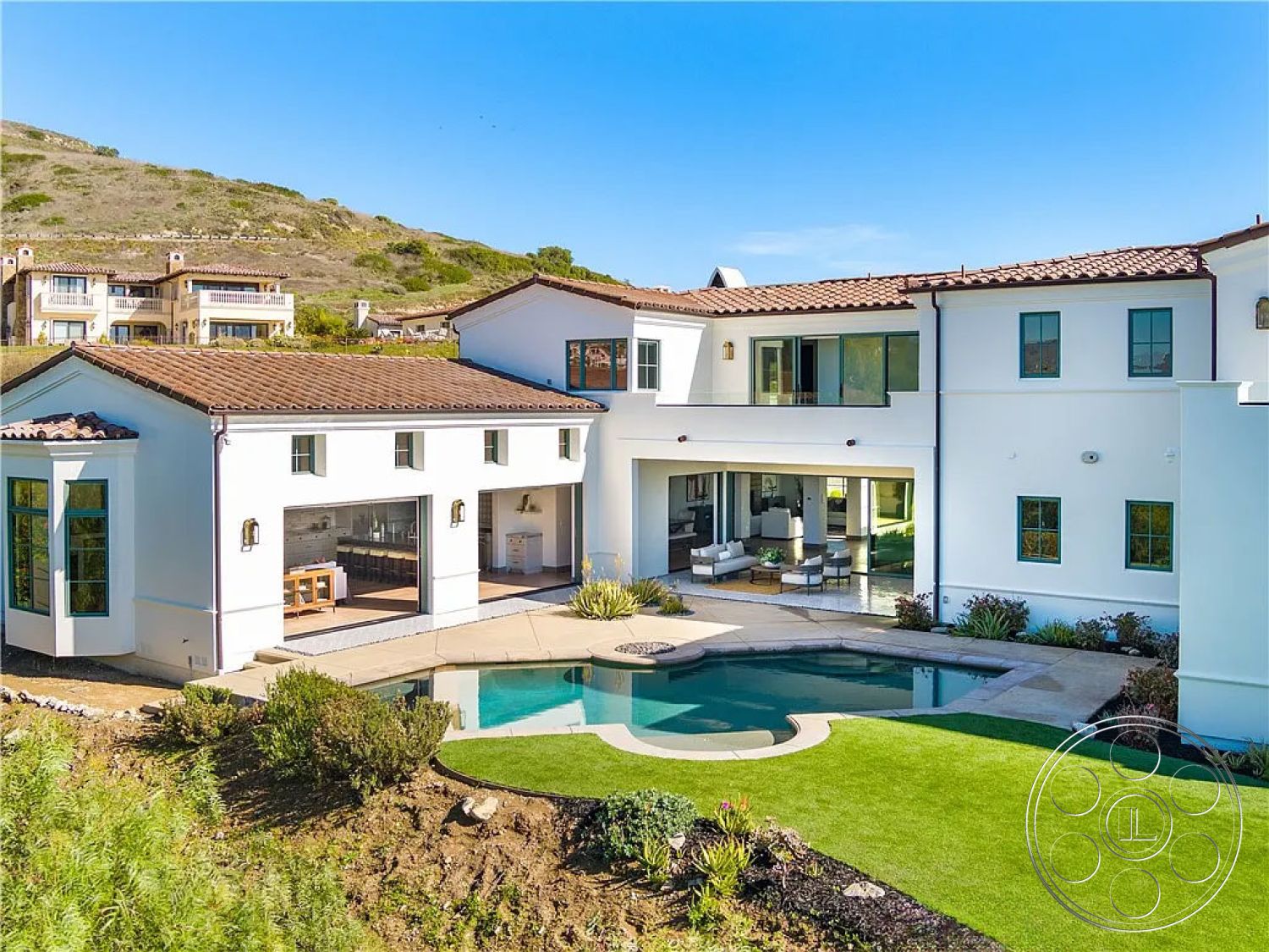Spanish 167 - landscaped garden, sliding glass doors, rectangular swimming pool, floor-to-ceiling windows, stone pathway, open-concept living space, outdoor dining space, Mediterranean architectural style, inviting pool area, stone pool deck, exterior white stucco walls, modern outdoor seating area, rural hillside location, concrete patio floor, grass lawn area, terra cotta tile roof, arched patio entrance, exposed beam ceilings, cabinets with modern finishes, stylish exterior lighting fixtures