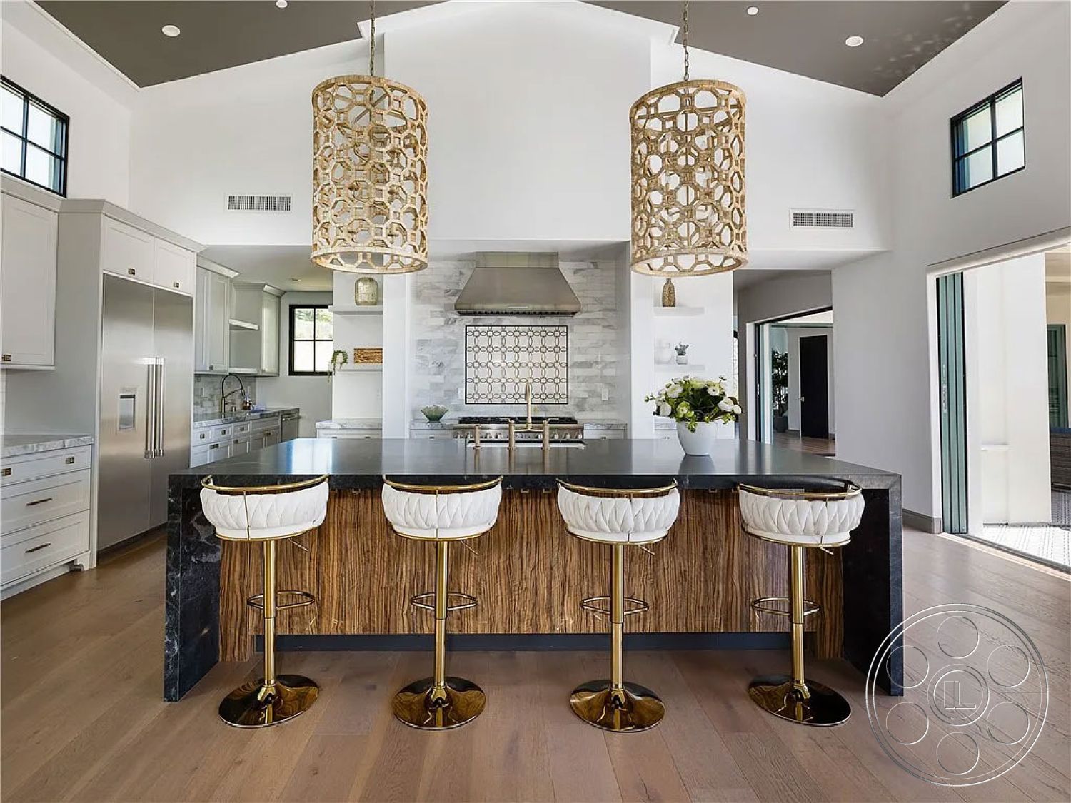 Spanish 167 - minimalist decor, neutral color palette, light hardwood flooring, stainless steel appliances, large windows for natural light, functional workspace, high vaulted ceiling, white shaker cabinets, open-concept design, decorative tile backsplash, interior kitchen space, marble kitchen countertops, contemporary kitchen style, exposed wood accent wall, black marble island, golden pendant light fixtures, modern barstools with gold accents, black and gold color scheme, geometric lighting design, kitchen island with seating
