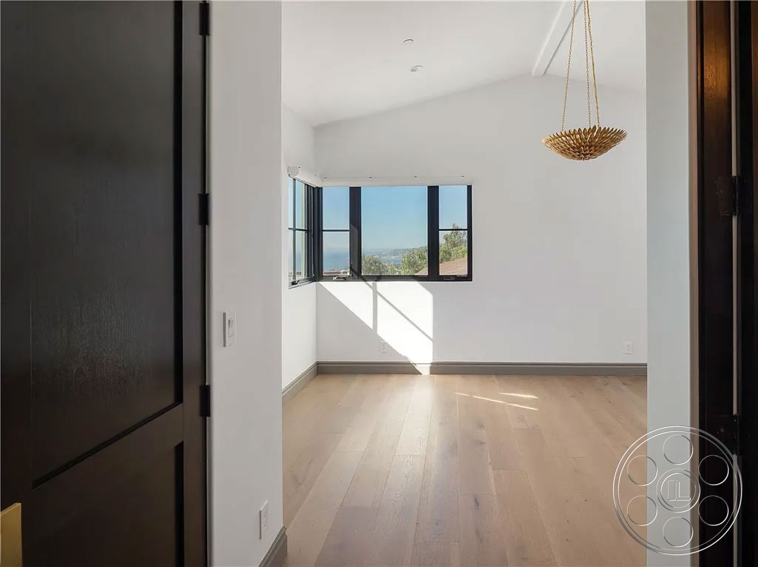 Spanish 167 - neutral color palette, natural light, minimalist design, open layout, vaulted ceiling, black framed windows, exposed ceiling beams, interior hardwood flooring, white painted walls, urban hillside view, gold pendant light fixture