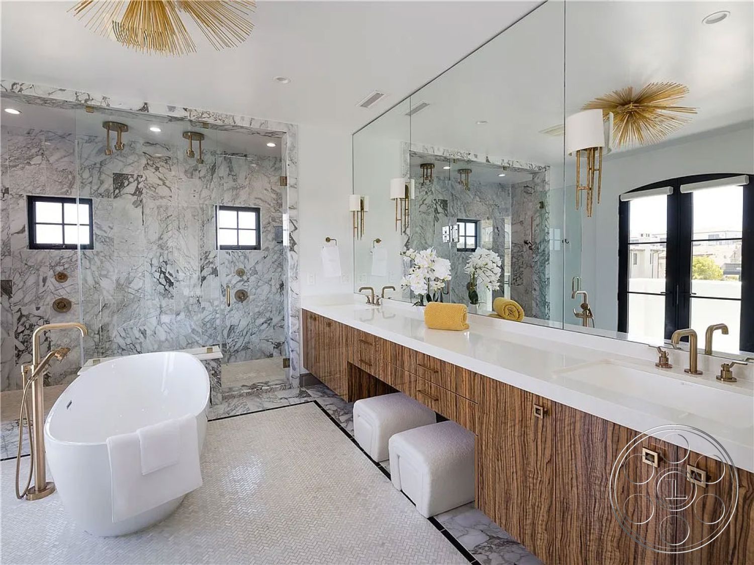 Spanish 167 - minimalist decor, modern pendant lighting, double sink vanity, black framed windows, white quartz countertop, glass shower doors, interior bathroom, white painted walls, freestanding soaking tub, marble shower walls, luxurious spa-like atmosphere, wood veneer vanity cabinet, herringbone mosaic tile flooring, brushed gold fixtures