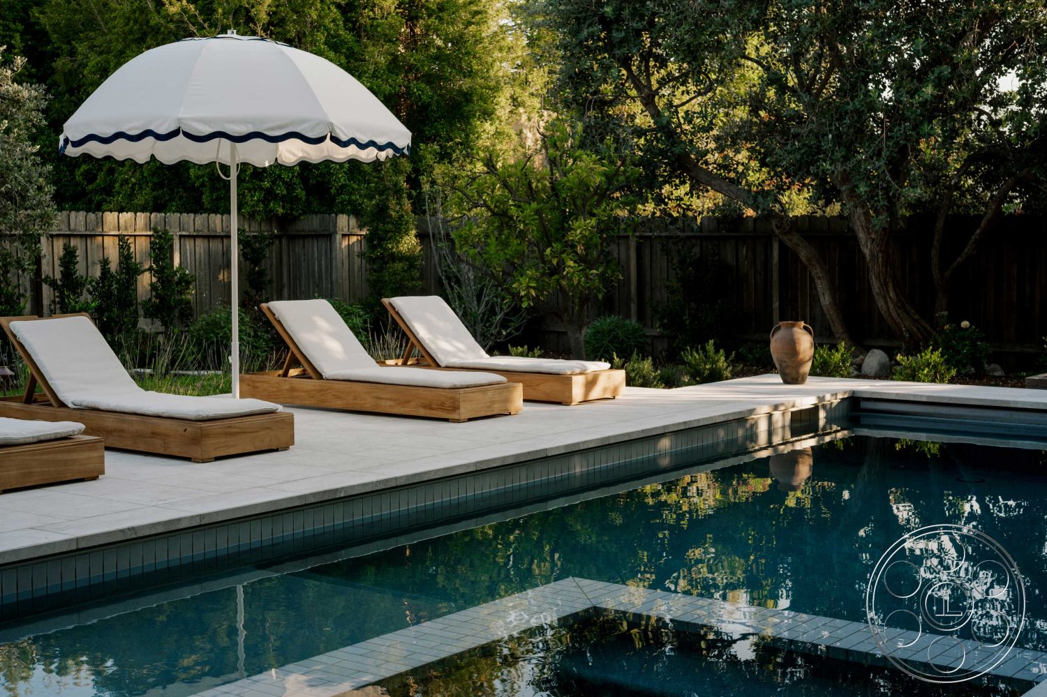 Americana 429 - modern design elements, rectangular swimming pool, lush landscaping, wooden lounge chairs, outdoor garden setting, stone patio flooring, concrete pool surround, textured umbrella, tile pool waterline, exterior lighting features