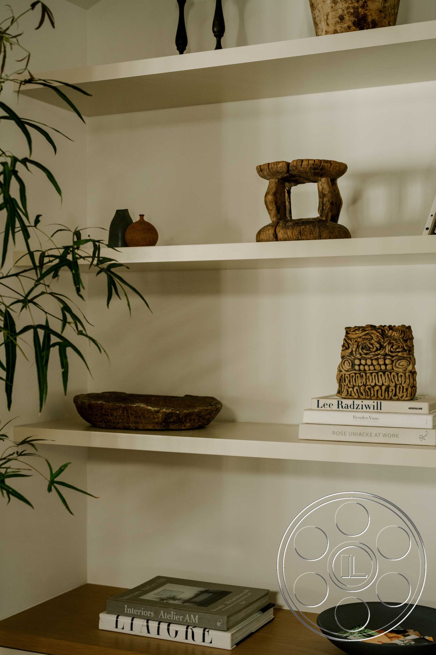 Americana 429 - minimalist decor, natural light, floating shelves, decorative plants, earthy color palette, contemporary aesthetic, stylish home office, white painted walls, organic wood decorative bowl, sculptural stone centerpiece, textured ceramic vase, dark wood bookshelf, modern art books, curated display