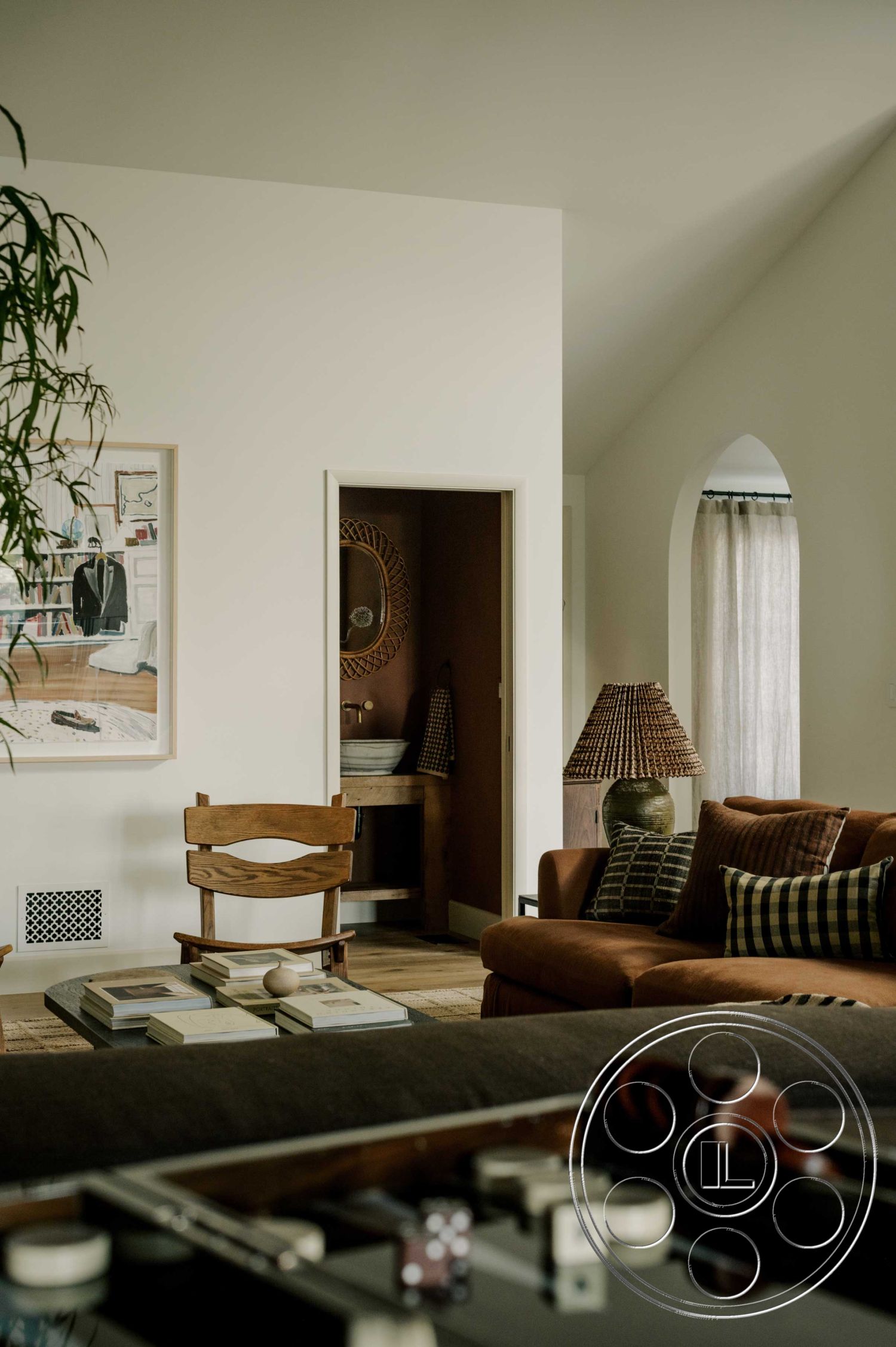 Americana 429 - interior vaulted ceiling, interior open doorway, interior hardwood living room floors, interior wooden accent chair, interior white painted walls, interior textured area rug, interior brown leather sofa, interior woven lampshade, interior decorative wall mirror, interior framed art piece, interior curtain window treatment, interior layered throw pillows
