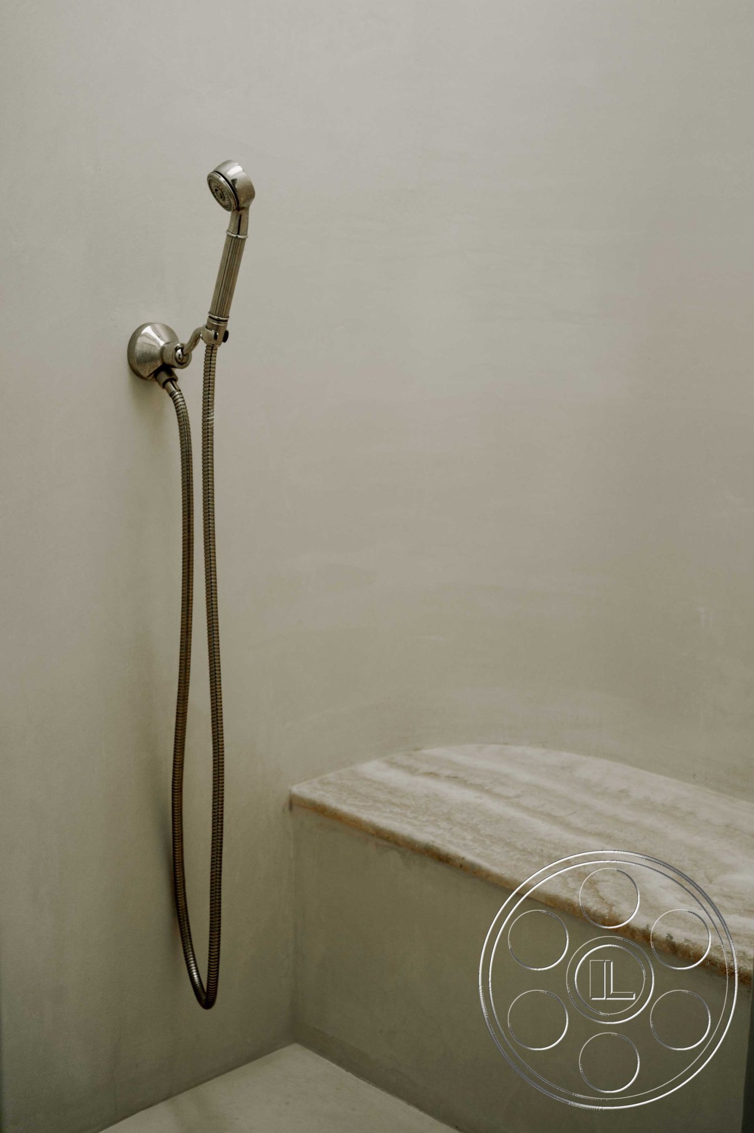 Americana 429 - neutral color palette, textured plaster bathroom walls, modern minimalist bathroom interior, natural stone shower bench, chrome shower fixture, spa-inspired shower design