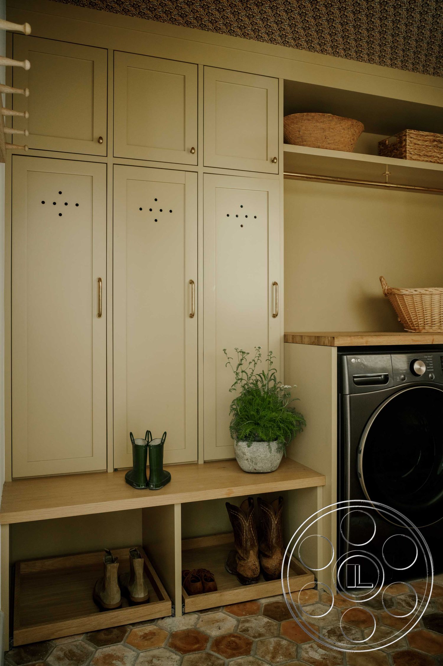 Americana 429 - hexagon tile flooring, soft lighting fixtures, modern farmhouse style, green indoor plant decor, interior mudroom cabinetry, painted wood storage lockers, oak bench seating, textured wallpaper ceiling, integrated laundry area, shoe storage compartment, metal drawer handles, functional mudroom design