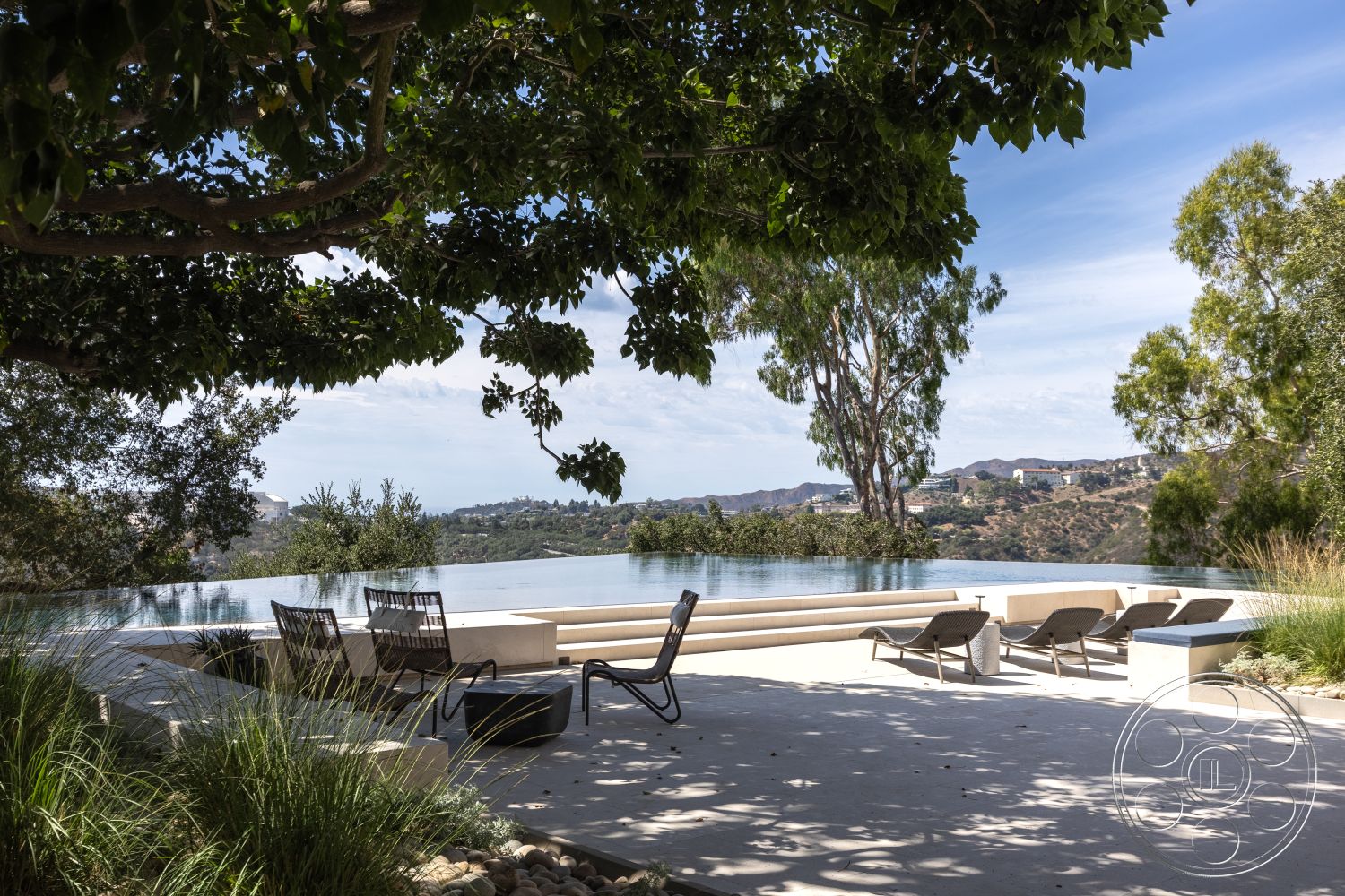 Modern 511 - natural wood accents, minimalist design elements, outdoor living space, infinity pool, shade from trees, hillside location, modern lounge chairs, sunny exterior, concrete patio flooring, landscaped garden setting, concrete pool border, concrete wall seating, scenic valley view