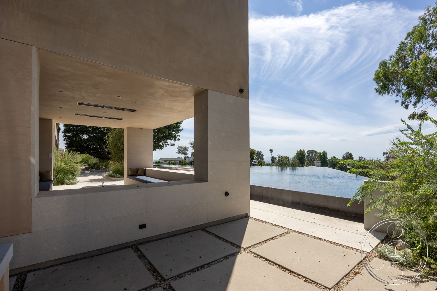 Modern 511 - surrounding greenery, outdoor living space, modern architectural style, open-air seating area, exterior concrete walls, minimalist landscape design, rectangular infinity pool, natural light entry, horizontal window arrangement, smooth stucco exterior finish, slate stone patio flooring, large glass window openings, exposed aggregate concrete pathways, suburban hillside setting, efficient drainage design