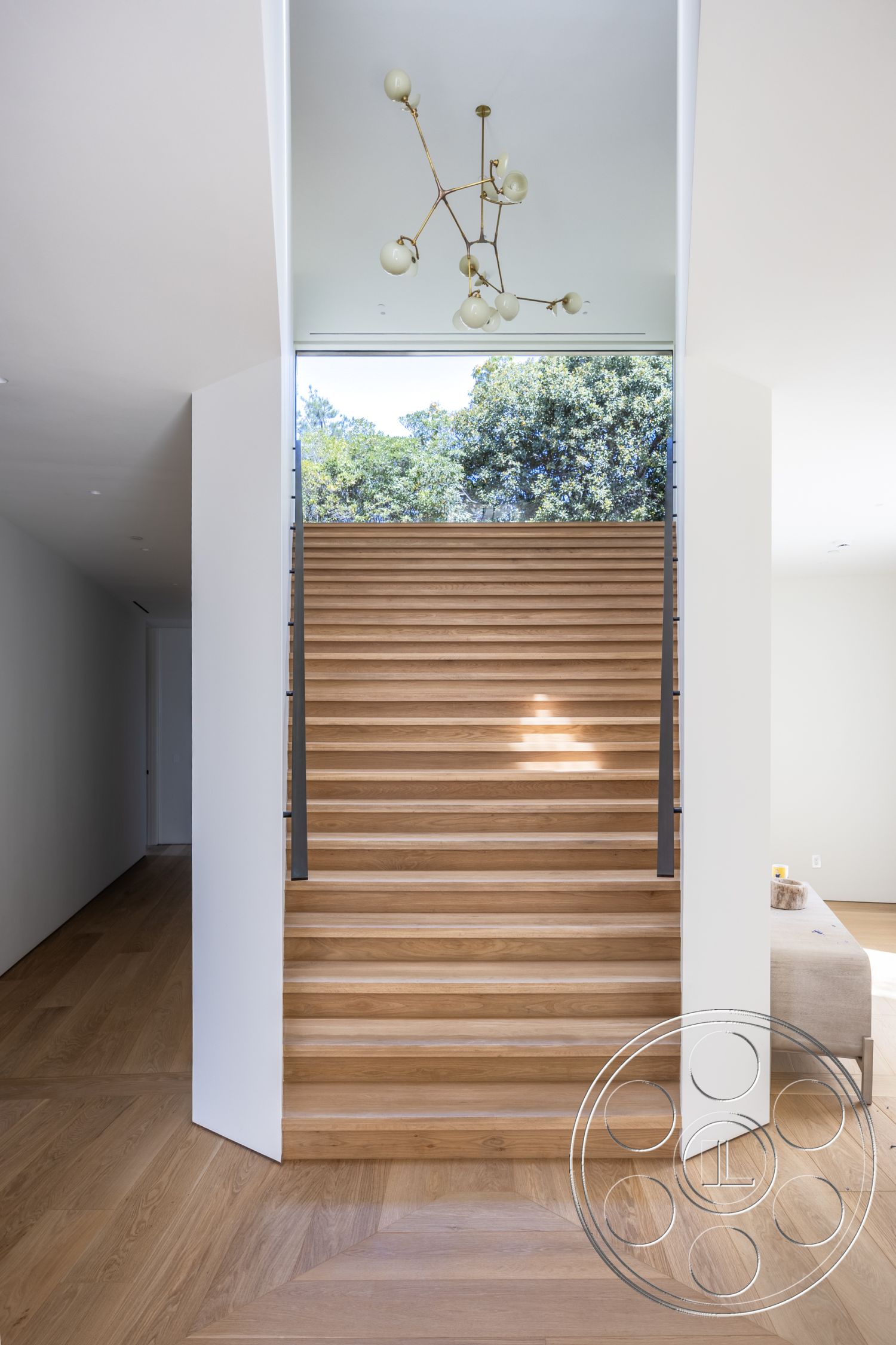 Modern 511 - large windows, hardwood flooring, clean lines, minimalist design, bright natural lighting, modern chandelier, expansive views, wooden handrail, geometric flooring pattern, open entryway, contemporary architectural style, white painted walls, floating stairs, oak staircase