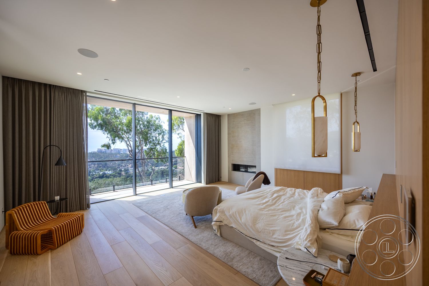 Modern 511 - neutral color palette, open concept layout, modern pendant lighting, floor-to-ceiling windows, large sliding glass doors, minimalist design aesthetic, hardwood bedroom floors, textured window treatments, glass railing balcony, interior master bedroom, exposed stone feature wall, plush bedding with decorative pillows, contemporary bedside table, curved armchair, black floor lamp, mountain view from bedroom, cozy relaxation space, elegant ceiling lighting