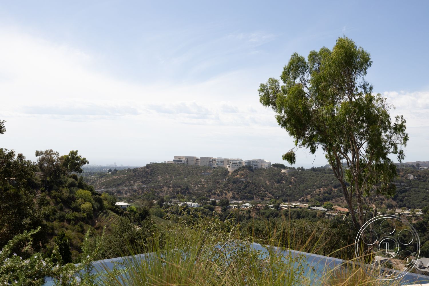 Modern 511 - residential neighborhood, contemporary architecture, city skyline view, infinity pool, lush greenery surrounding, sunny outdoor environment, urban hillside setting, landscape vegetation, glass pool border, modern exterior building, natural hillside contour, open aerial views