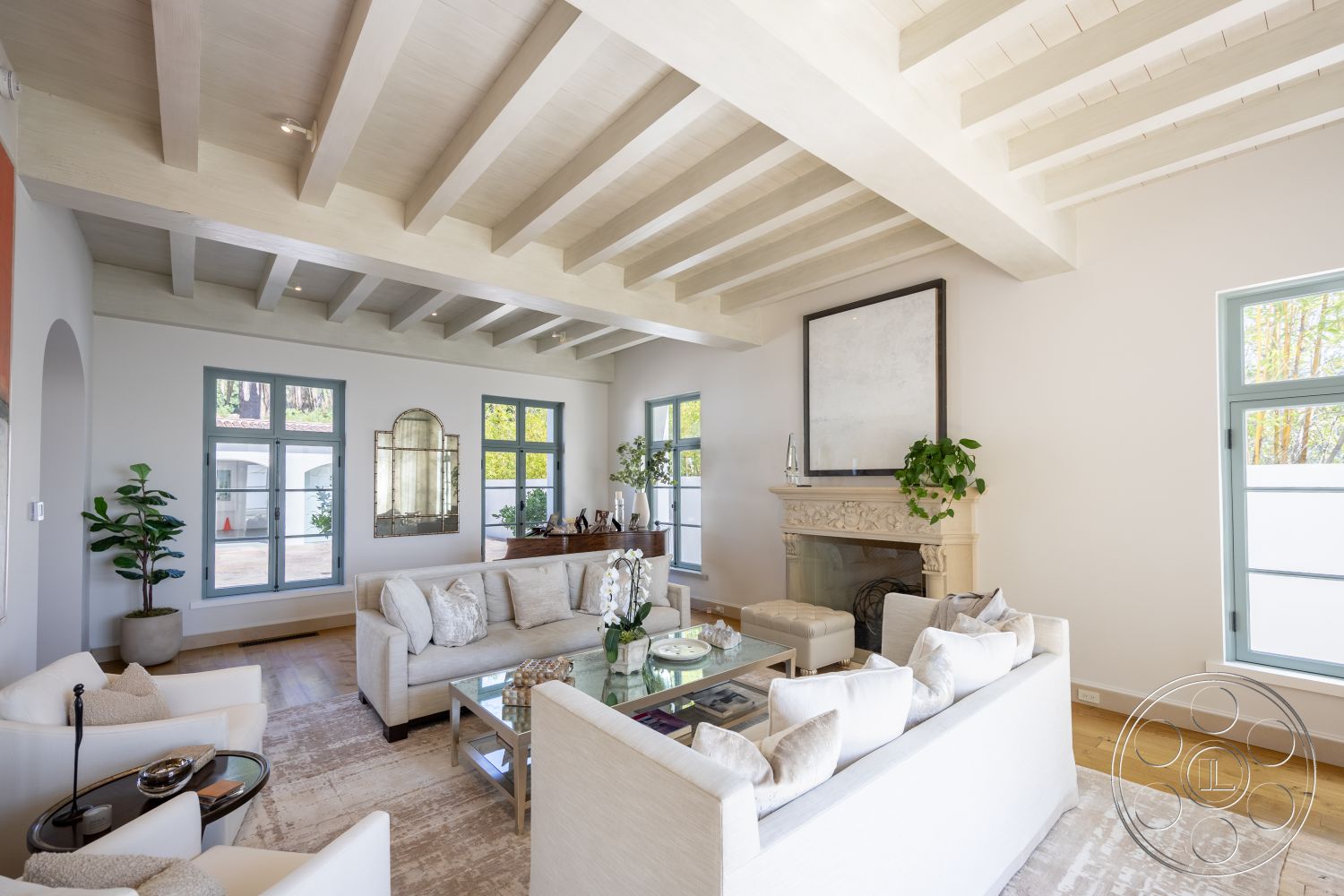 Spanish 168 - neutral color palette, glass coffee table, minimalist design elements, modern art wall decor, floor-to-ceiling windows, mid-century modern furniture, comfortable seating area, indoor plant decor, exposed wood ceiling beams, hardwood living room floors, interior living room, natural light-filled space, white painted walls, open floor plan interior, decorative stone fireplace surround, light-colored area rug, rectangular living room layout, urban suburban transition living