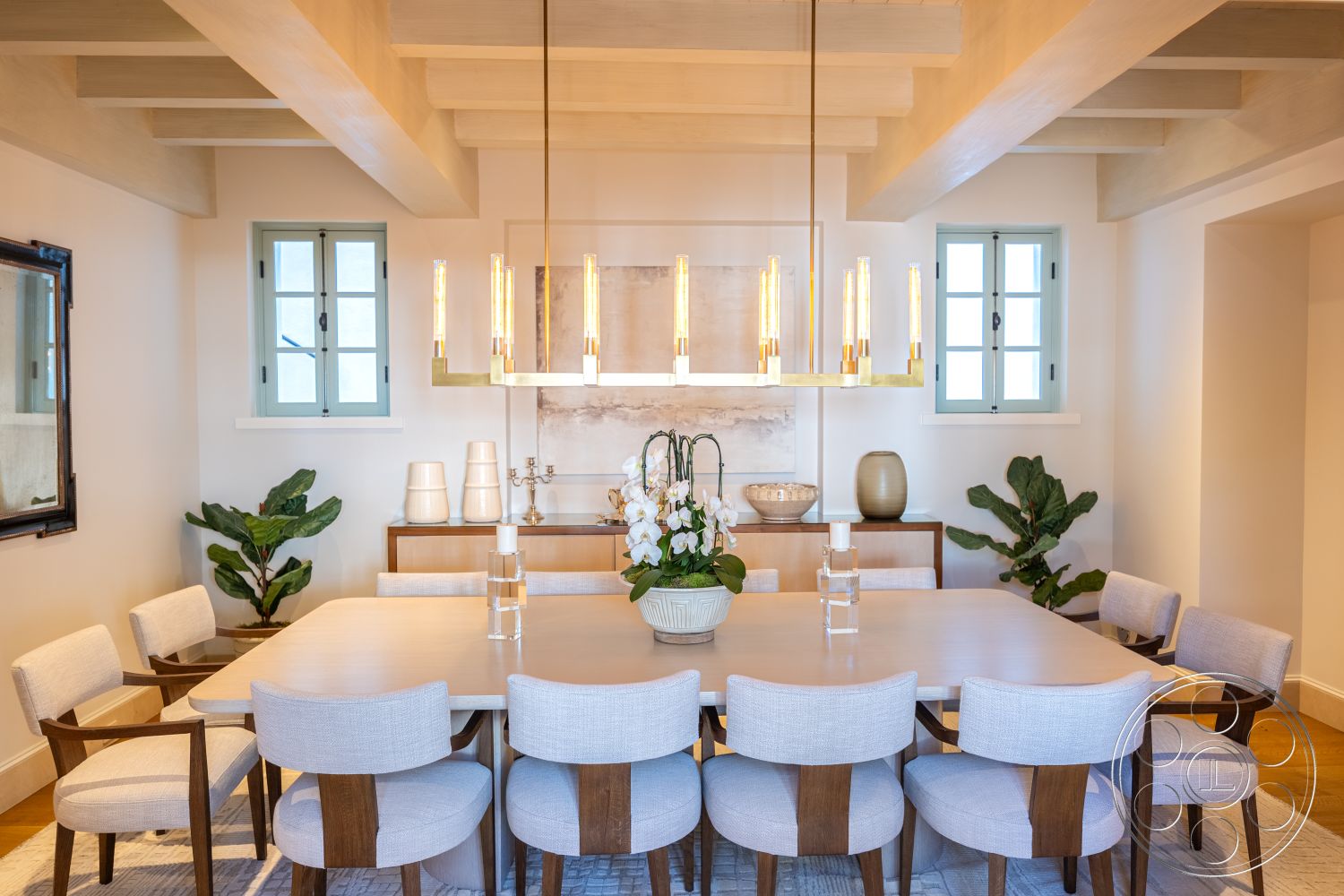 Spanish 168 - minimalist decor, neutral color palette, hardwood flooring, textured wall art, decorative vases, upholstered dining chairs, floor-to-ceiling windows, geometric area rug, elegant chandelier, glass pendant lighting, modern dining table, interior dining room, wood beam ceiling, natural plant accents, modern sideboard, cool-toned painted windows, formal dining setup