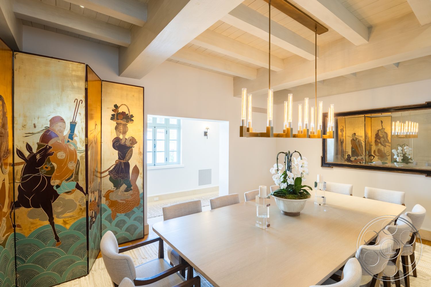 Spanish 168 - neutral color palette, textured area rug, upholstered dining chairs, natural wood dining table, interior dining room, open floor plan layout, wood beam ceiling, modern chandelier lighting, artistic folding screen, gold leaf decorative panel, glass vase with orchids, light-colored wall paint, full-length mirror artwork, large windows with light curtains