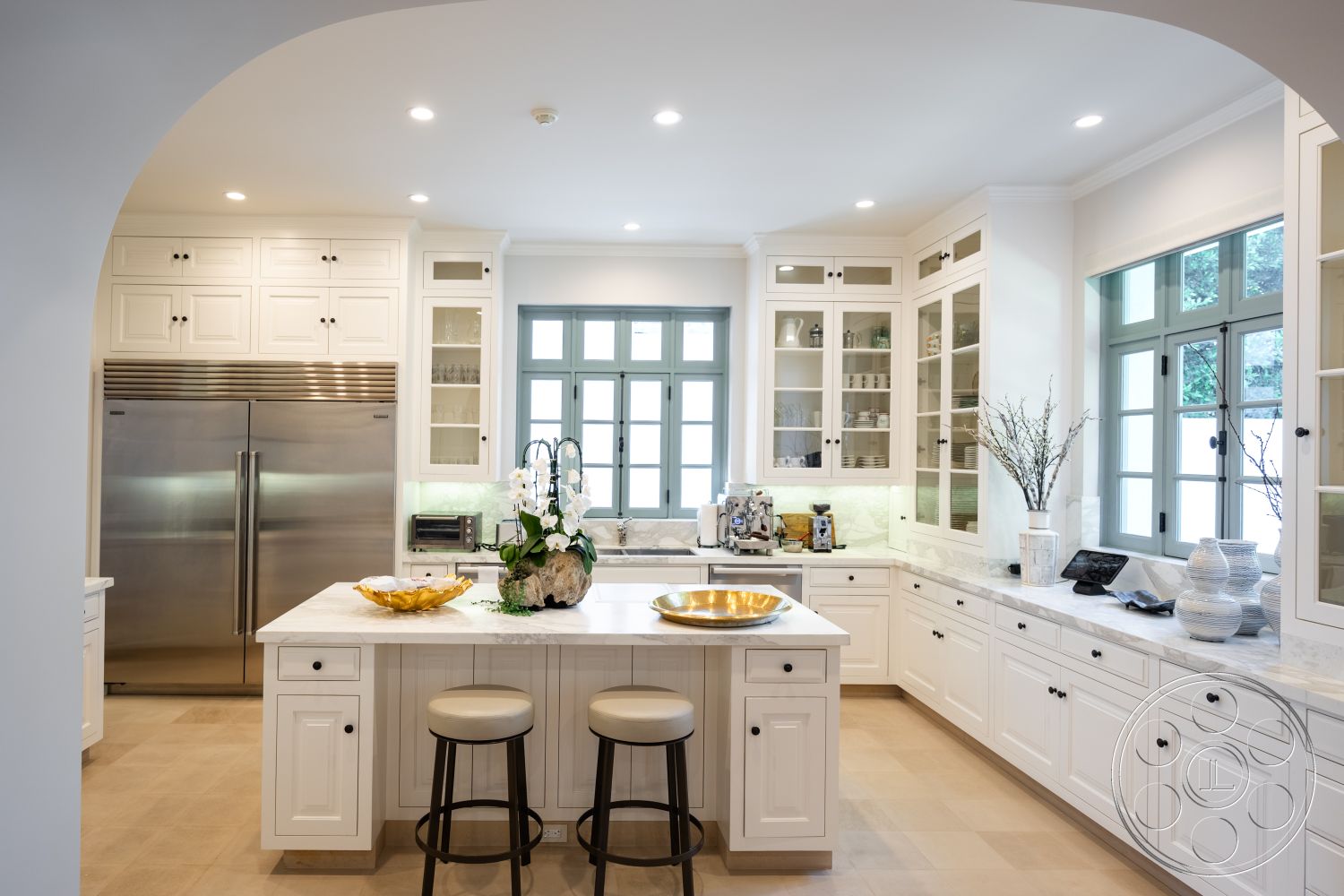 Spanish 168 - stainless steel refrigerator, marble kitchen countertops, recessed ceiling lighting, functional kitchen workspace, neutral color palette interior, white shaker kitchen cabinets, open concept kitchen design, tile kitchen flooring, decorative glass cabinet doors, soft close kitchen drawers, dual basin kitchen sink, island with bar seating, undermount kitchen sink, windowed kitchen nook, textured backsplash tiles, arched entryway to kitchen, custom kitchen millwork, elegant kitchen decor elements, kitchen with garden view