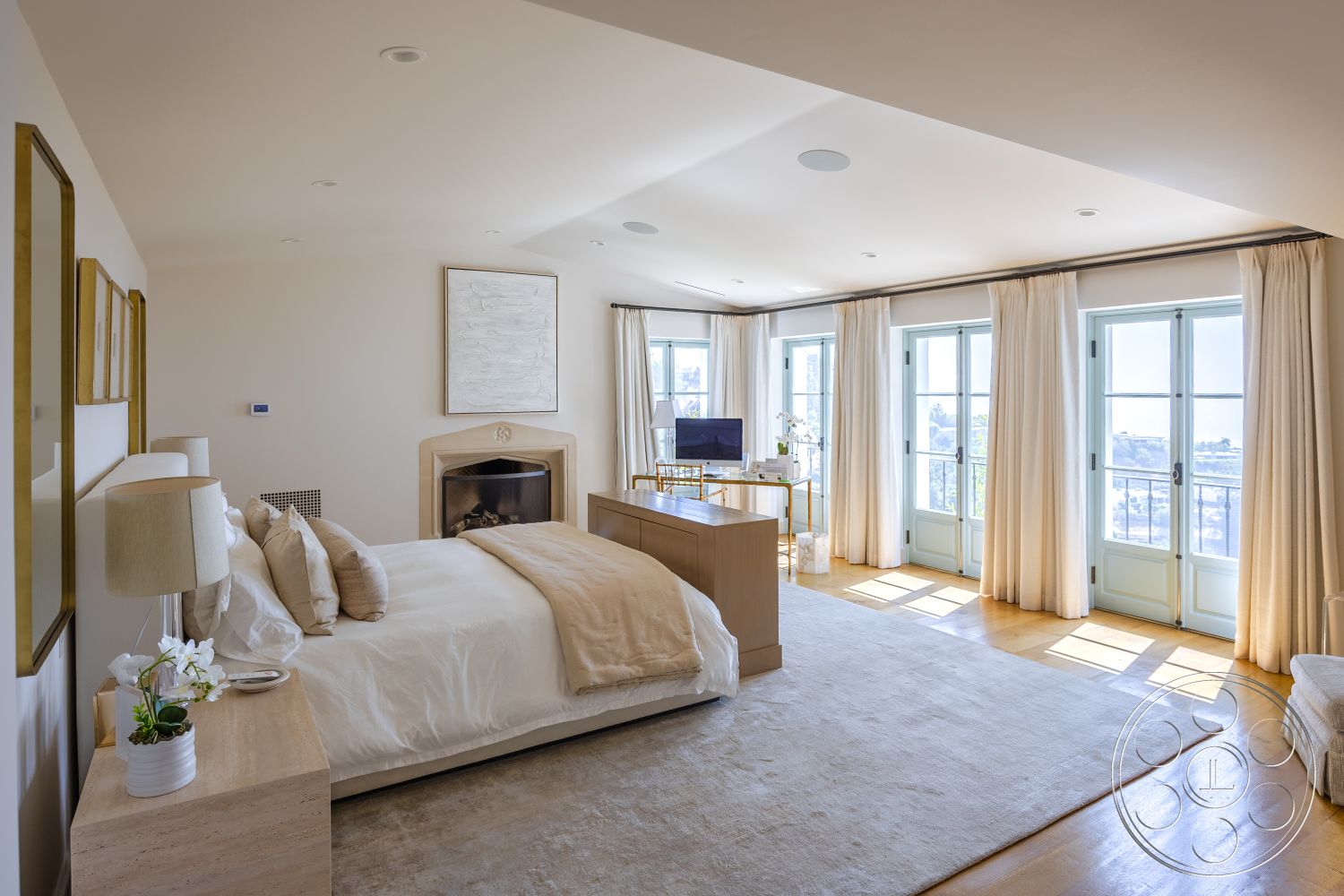 Spanish 168 - textured area rug, mountain view setting, minimalist decor elements, hardwood bedroom floors, coffered ceiling details, plaster painted walls, fireplace with stone surround, glass balcony doors, modern bedroom furniture, warm neutral color palette, draped window treatments